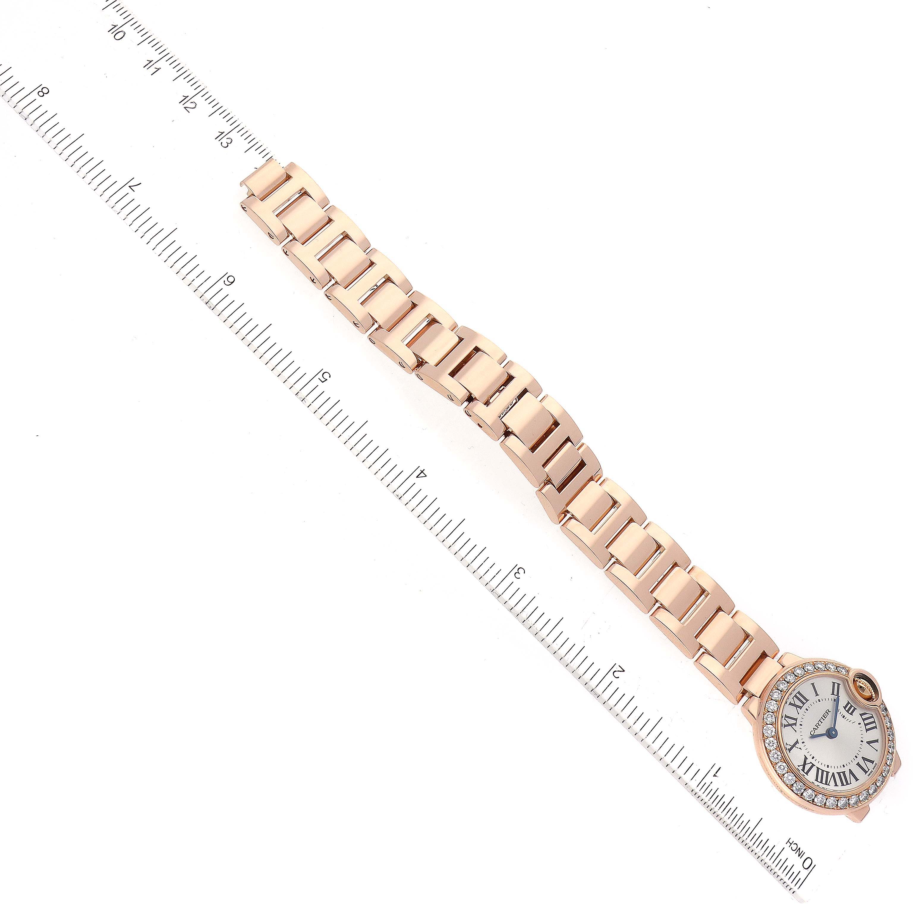This image shows a top view of a Cartier Ballon Bleu WJBB0015 Women's Rose Gold Silver Dial WJBB0015 Women's Rose Gold Silver Dial watch, showcasing its face and bracelet next to a ruler.