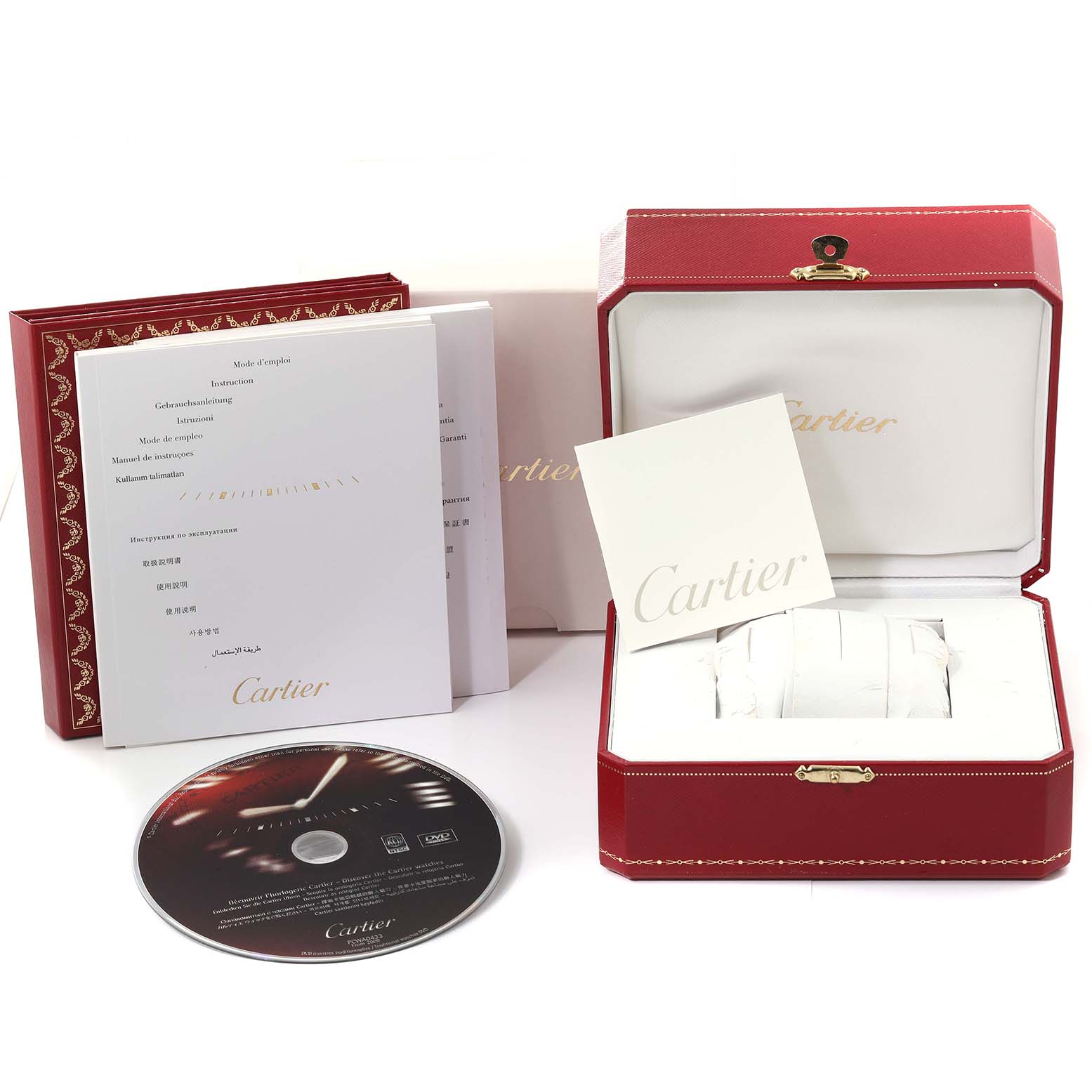 The image shows the packaging and accessories for the Cartier Tank Americaine W26019L1 Women's White Gold Silver Dial W26019L1 Women's White Gold Silver Dial watch, including booklets, a CD, and the watch box.