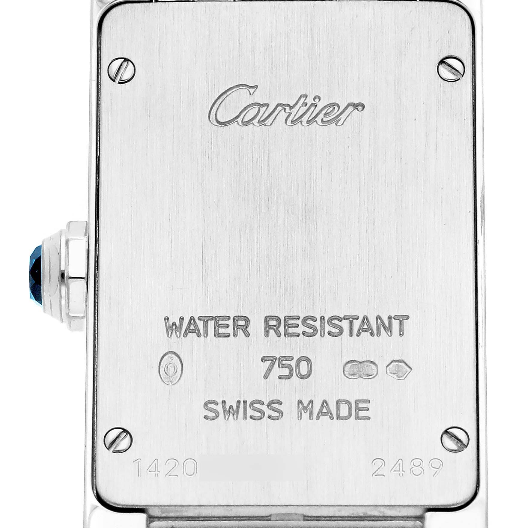 The image shows the back case of a Cartier Tank Américaine watch, featuring engravings and a visible crown with a blue gemstone.