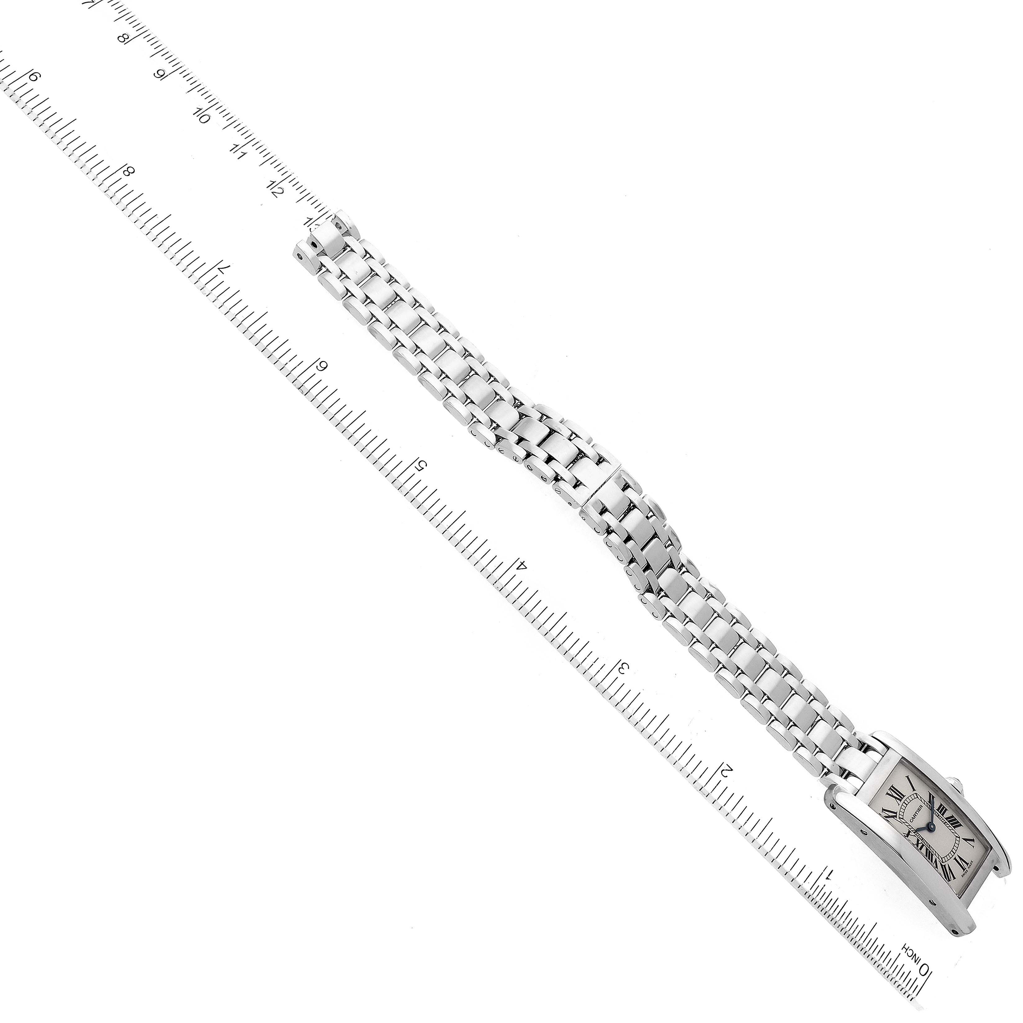 The image shows a Cartier Tank Americaine W26019L1 Women's White Gold Silver Dial W26019L1 Women's White Gold Silver Dial watch placed flat, with the face and metal bracelet aligned with a ruler for measurement.
