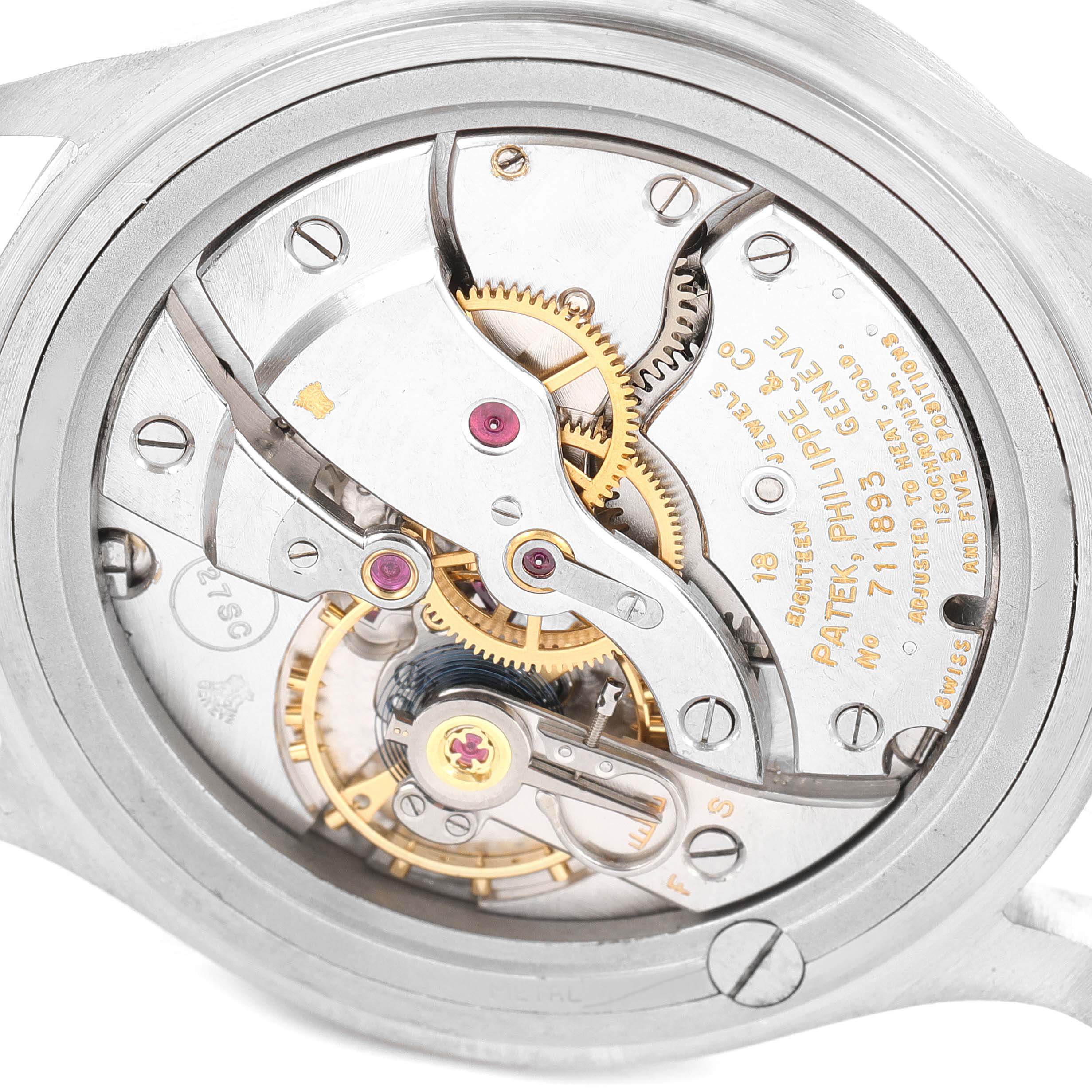The image shows the intricate mechanical movement of a vintage Patek Philippe watch from the back.