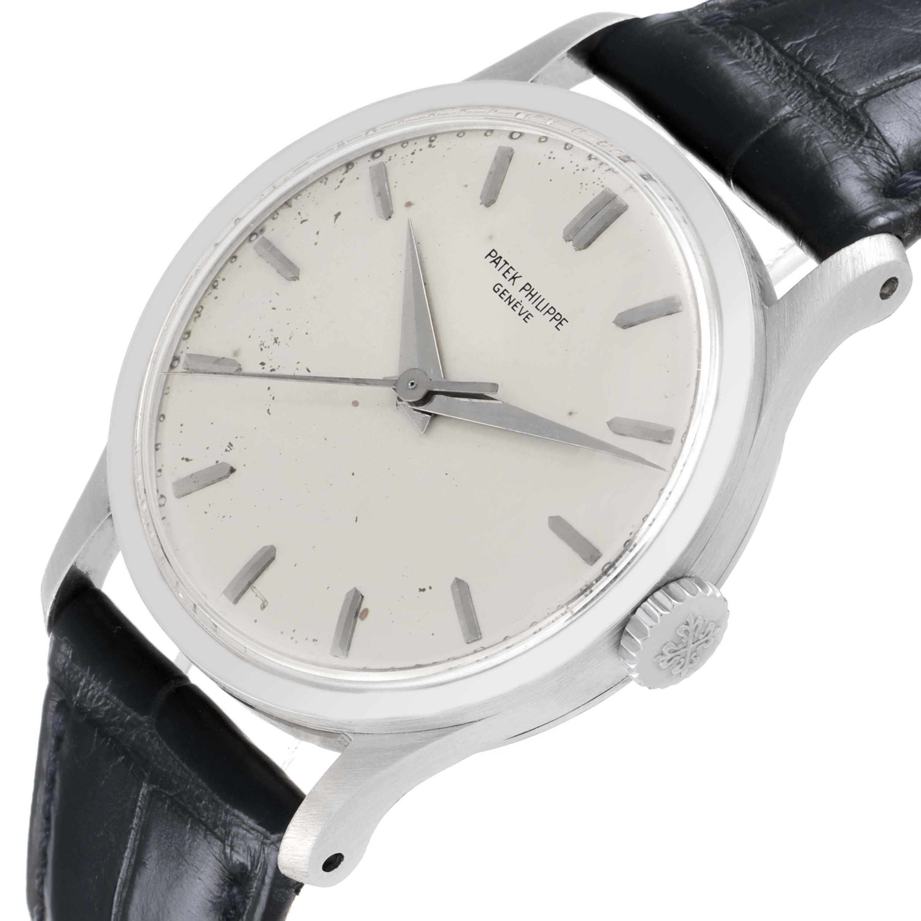 The Patek Philippe Calatrava 570 Men's White Gold Silver Dial watch is shown at a tilted angle, highlighting the dial, crown, and part of the leather strap.