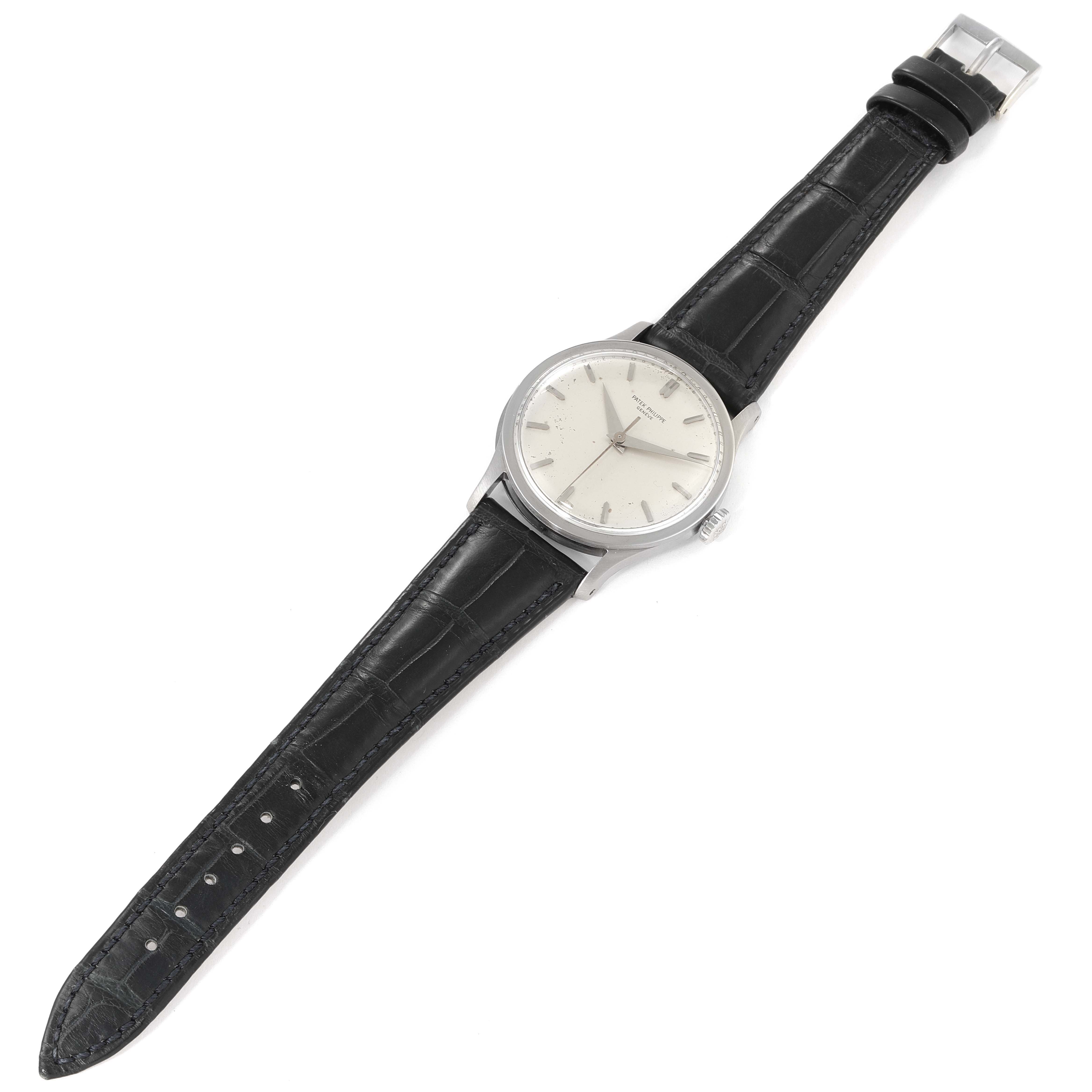 This image shows a Vintage Patek Philippe watch with a black leather strap and a silver case at a slight top-down angle.