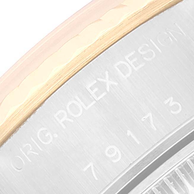This close-up image shows the engraved side of the case of a Rolex Datejust 79173 Women's Steel and Gold (two tone) White Dial 79173 Women's Steel and Gold (two tone) White Dial watch.
