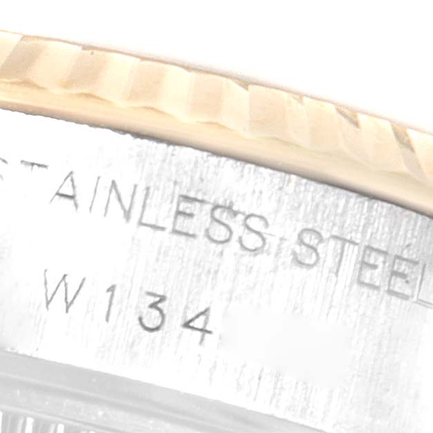 This close-up image features the engraved side of the casing and the fluted bezel of a Rolex Datejust 69173 Women
s Steel and Gold (two tone) Champagne Dial 69173 Women
s Steel and Gold (two tone) Champagne Dial watch.