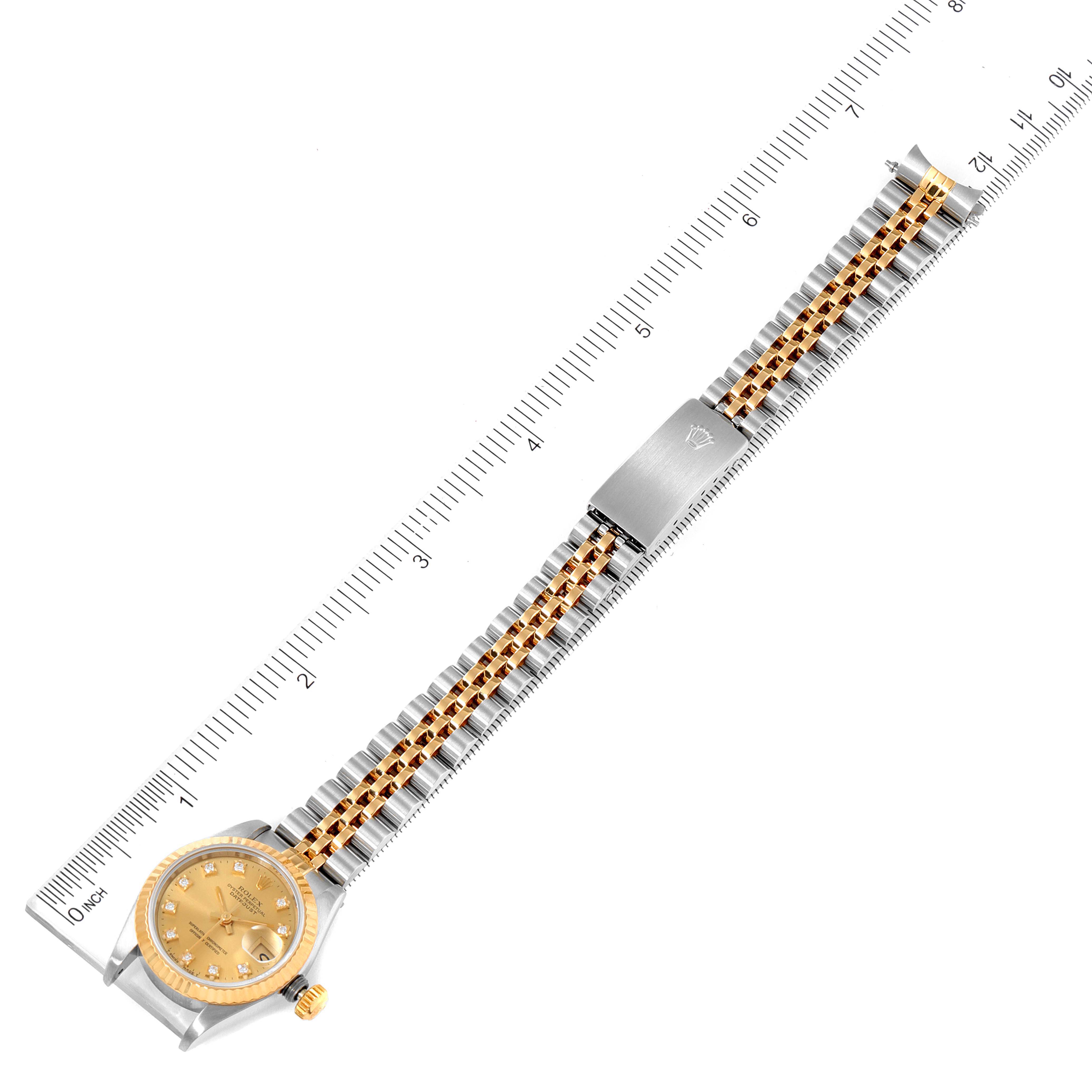 The image shows a top-down view of a Rolex Datejust 69173 Women
s Steel and Gold (two tone) Champagne Dial 69173 Women
s Steel and Gold (two tone) Champagne Dial watch with its bracelet fully extended alongside a ruler for measurement.