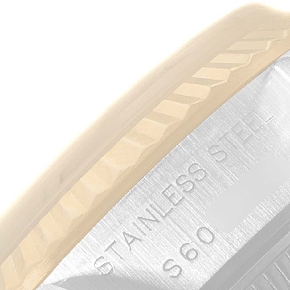 The image shows a close-up of the case back edge and part of the fluted bezel of a Rolex Datejust 69173 Women
s Steel and Gold (two tone) Champagne Dial 69173 Women
s Steel and Gold (two tone) Champagne Dial watch, revealing "STAINLESS STEEL" engraving.