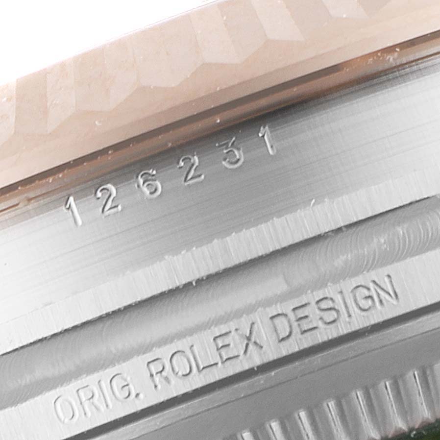 This is a close-up of the Rolex Datejust 126231 Men's Rose Gold Grey Dial 126231 Men's Rose Gold Grey Dial model, showing part of the bezel and case with engraved details.