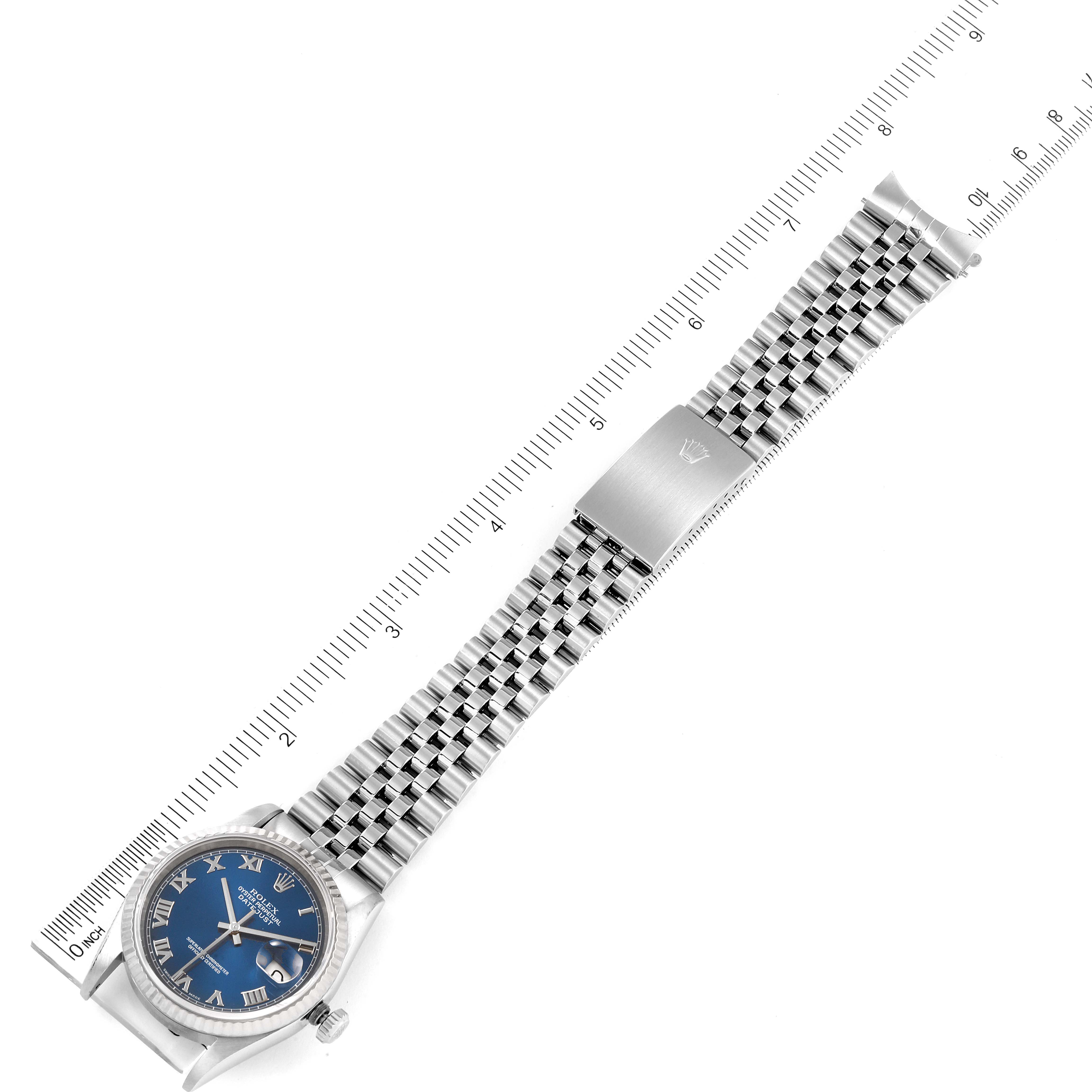 This overhead view shows the Rolex Datejust 16234 Men's Stainless Steel Blue Dial 16234 Men's Stainless Steel Blue Dial watch and its stainless steel bracelet, aligned with a ruler for scale.