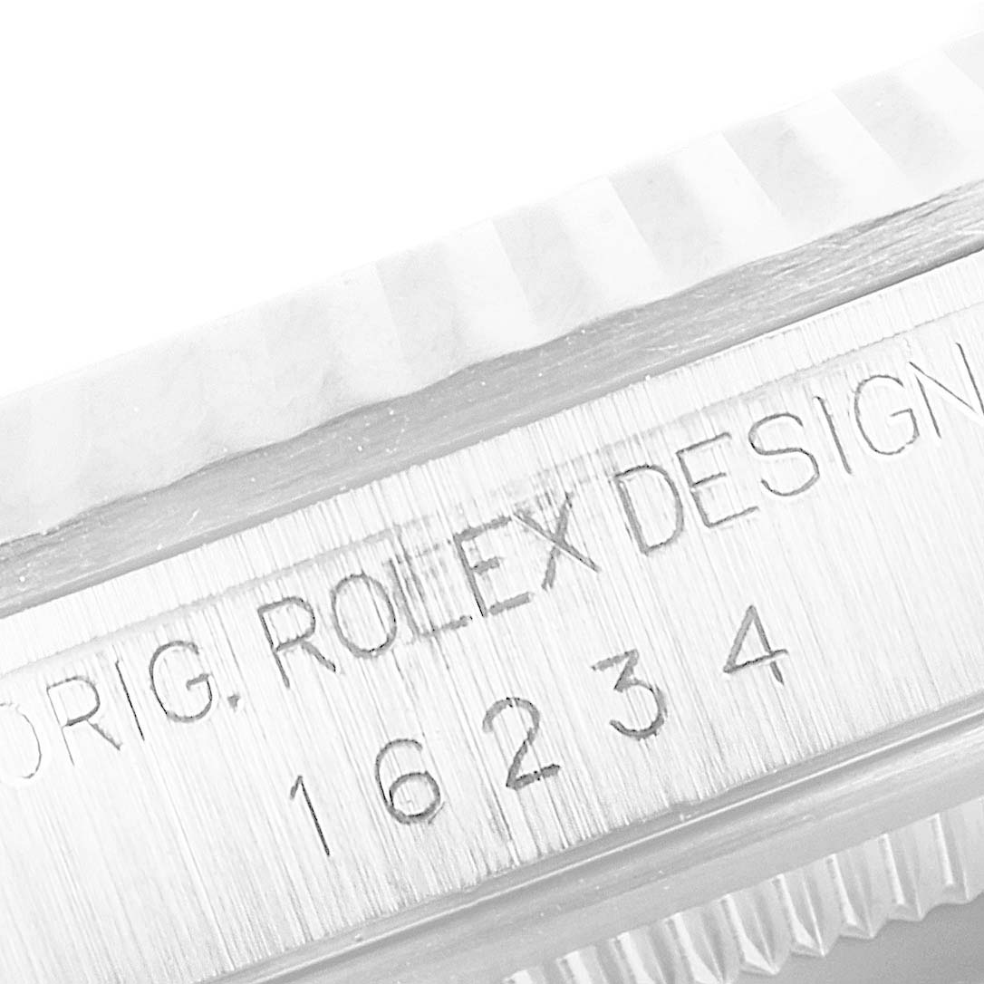 The image shows a close-up of the Rolex Datejust 16234 Men's Stainless Steel Blue Dial 16234 Men's Stainless Steel Blue Dial model's serial number and the inscription "ORIG. ROLEX DESIGN" on the case.