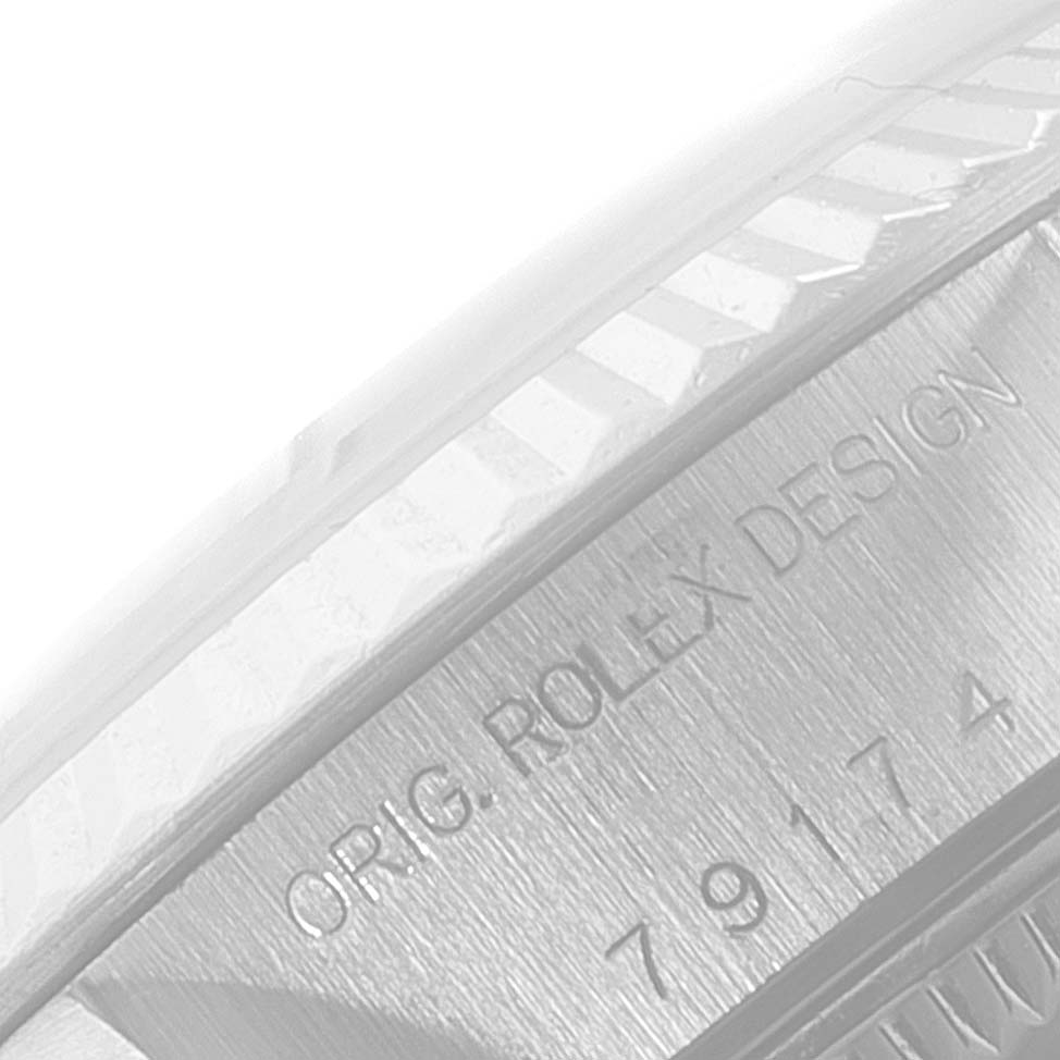 This image shows a close-up of the side of the bezel and case of a Rolex Datejust 79174 Women's Stainless Steel Blue Dial 79174 Women's Stainless Steel Blue Dial watch with visible engravings.