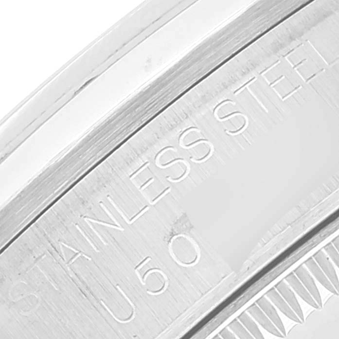 This image shows a close-up of the back casing and part of the bezel of a mid-size Rolex watch, displaying "STAINLESS STEEL" engraving.