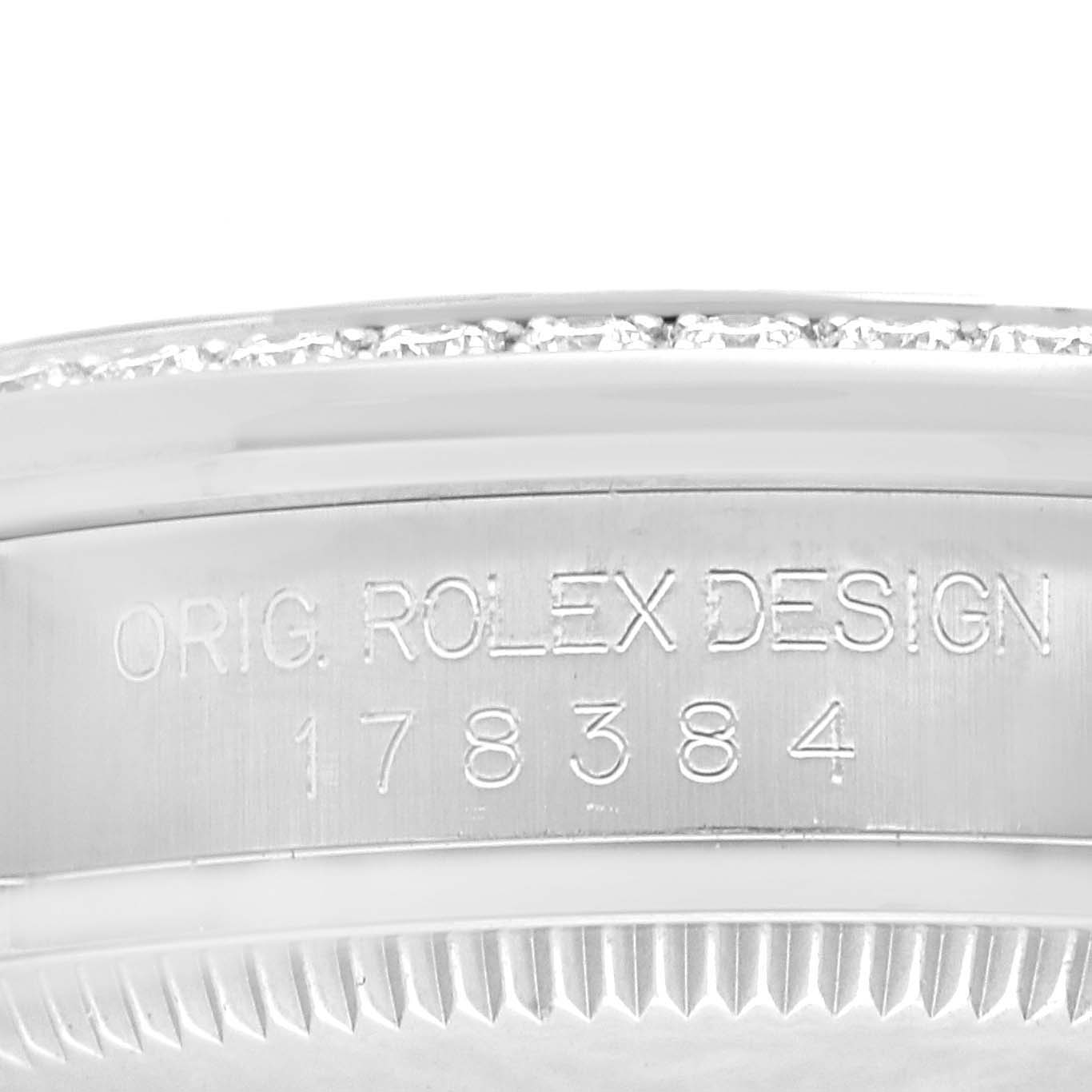 The image shows a close-up of the case side and part of the bezel of a Mid-Size Rolex watch, revealing the design engraving and part of the serial number.