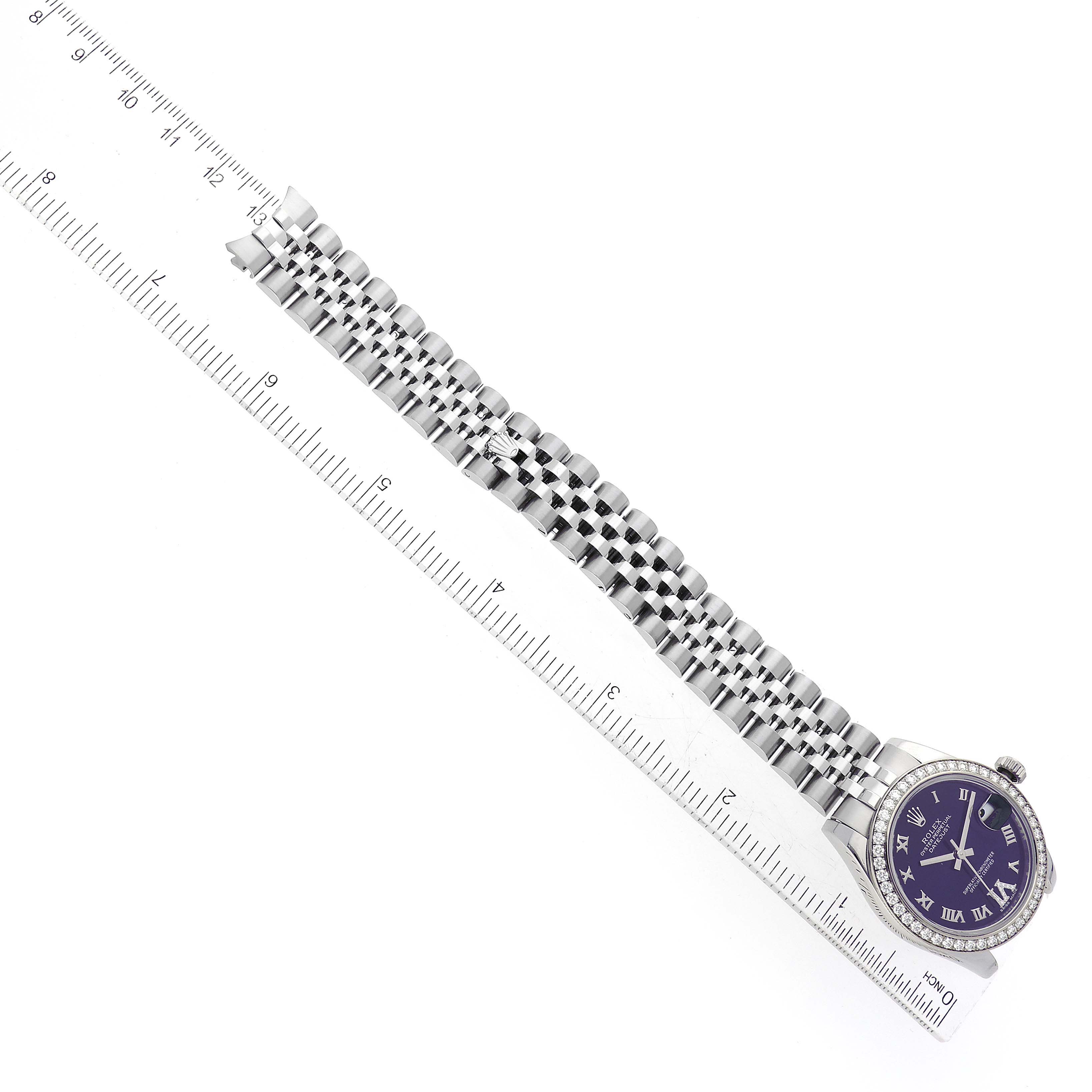 The Mid-Size Rolex watch is shown flat, displaying the face, case, and full bracelet next to a ruler.