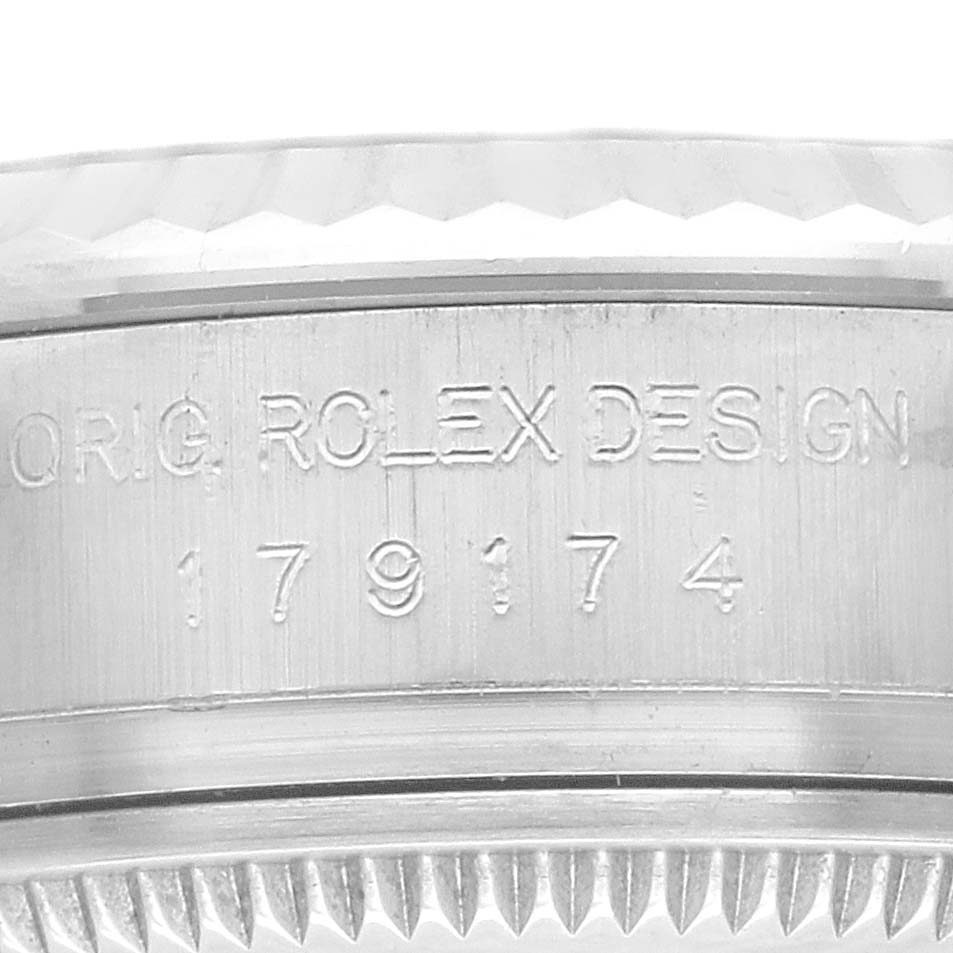 The image shows a close-up of the side of the case of a Rolex Datejust 179174 Women's Stainless Steel Blue Dial 179174 Women's Stainless Steel Blue Dial watch, highlighting the model number and design inscription.