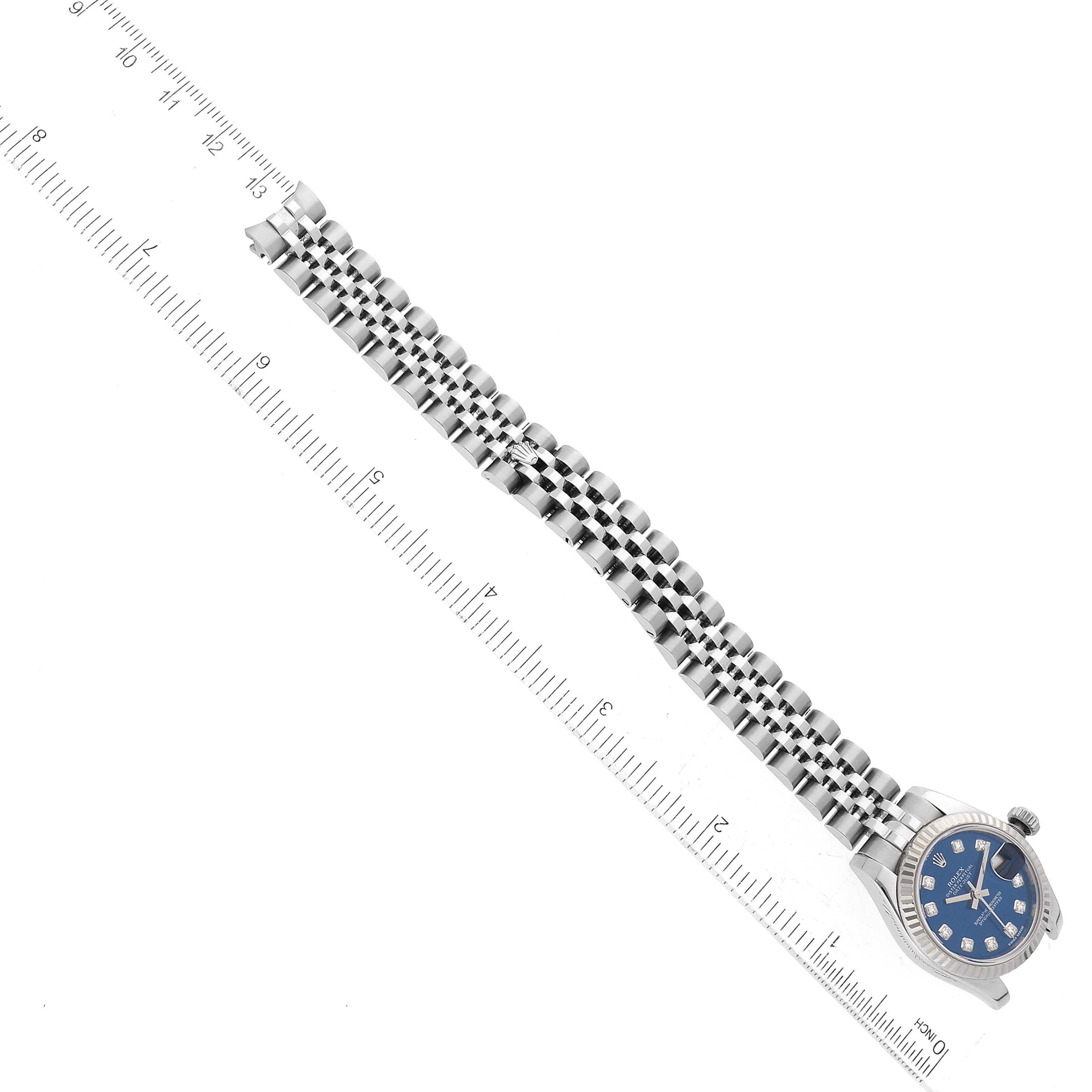 The image shows a Rolex Datejust 179174 Women's Stainless Steel Blue Dial 179174 Women's Stainless Steel Blue Dial watch with a blue dial and a stainless steel jubilee bracelet, positioned next to a ruler.