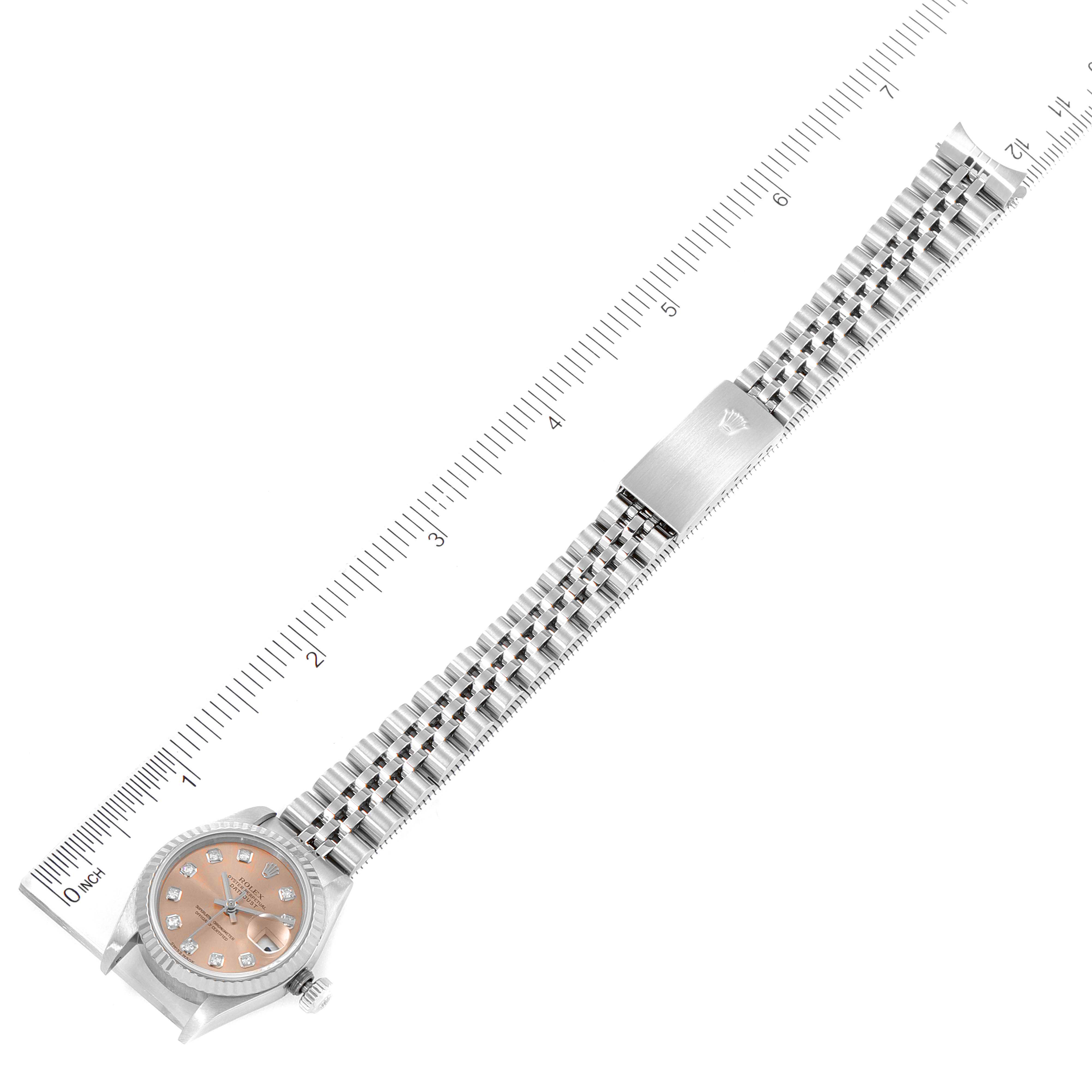 The image shows the Rolex Datejust 79174 Women's Stainless Steel Pink Dial 79174 Women's Stainless Steel Pink Dial watch from an overhead angle, highlighting the dial, case, and bracelet with a measurement scale.