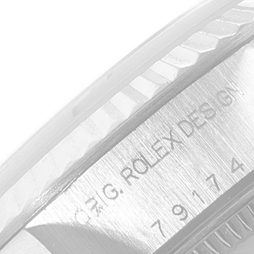 The image shows a close-up of the side of the case and bezel of a Rolex Datejust 79174 Women's Stainless Steel Pink Dial 79174 Women's Stainless Steel Pink Dial, highlighting the engraved text and model number.