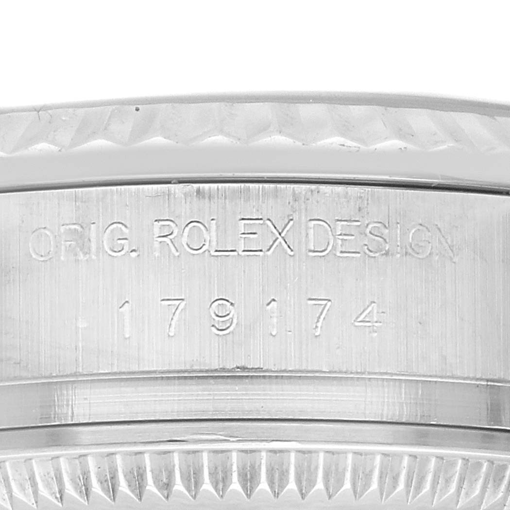 The image shows a close-up angle of the side of a Rolex Datejust 179174 Women
s Stainless Steel Silver Dial 179174 Women
s Stainless Steel Silver Dial watch with visible engravings of "ORIG. ROLEX DESIGN" and the model number.