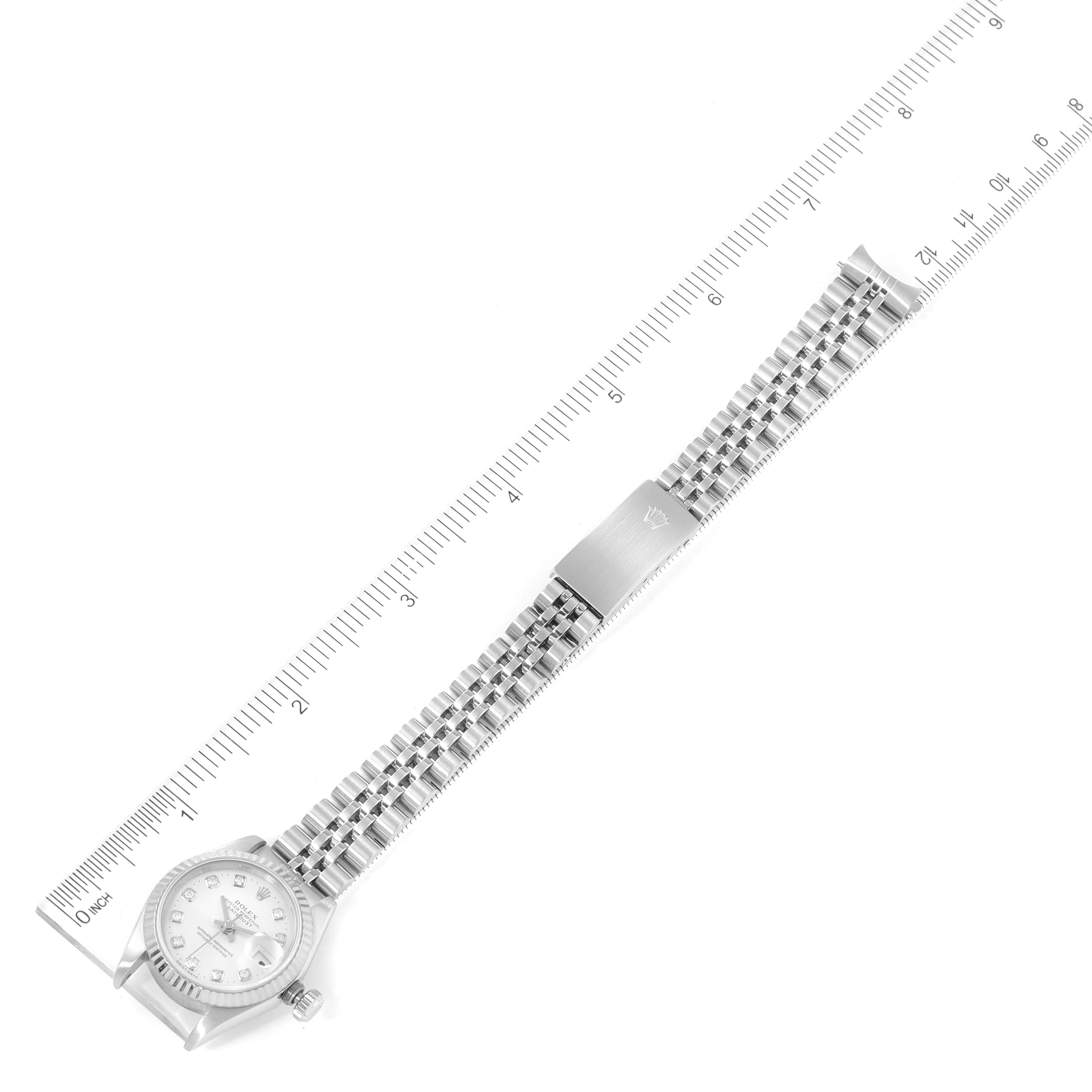 This image shows a top-down view of a Rolex Datejust 69174 Women
s Stainless Steel Silver Dial 69174 Women
s Stainless Steel Silver Dial watch, displaying the full bracelet and dial against a ruled background.