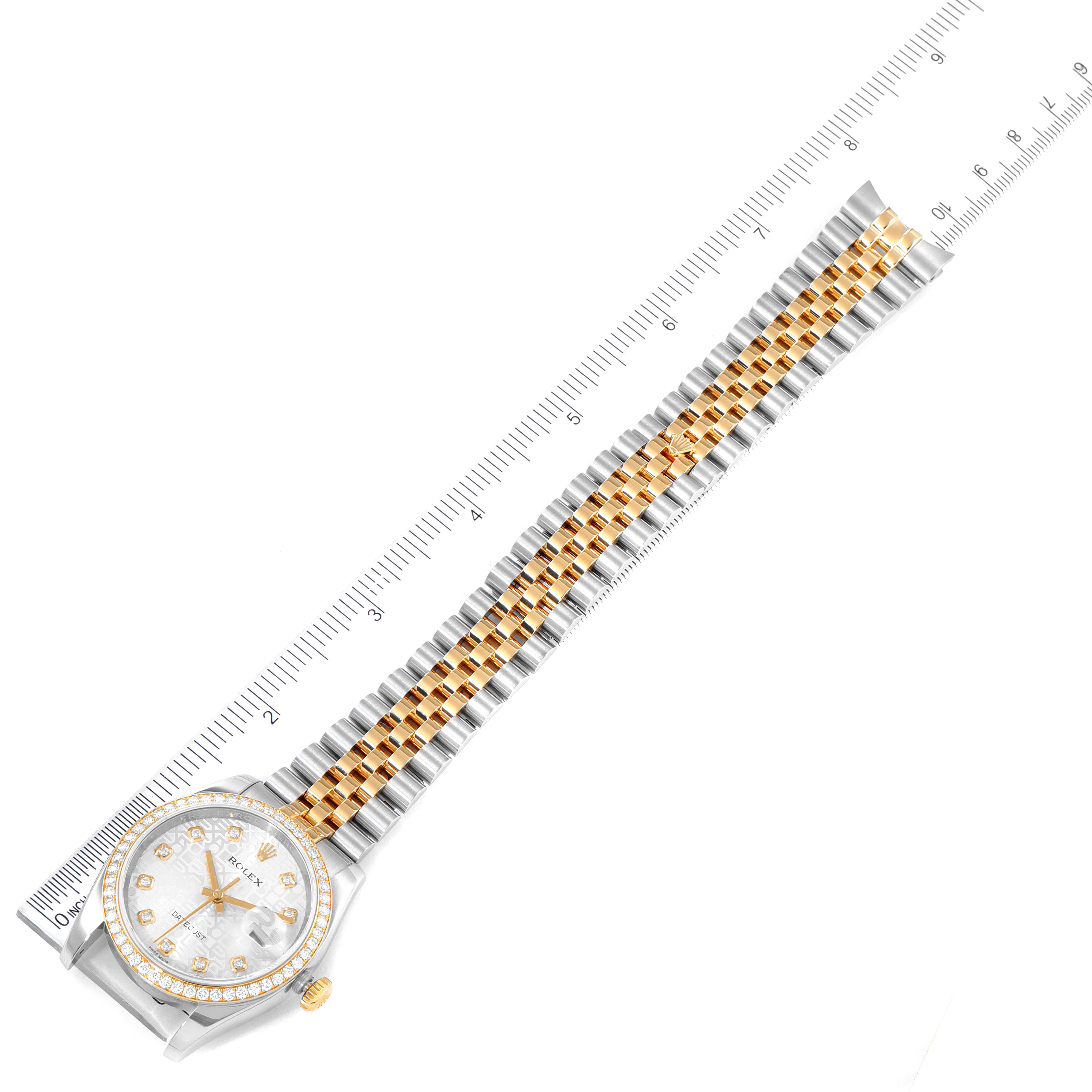 The Rolex Datejust 116243 Men's Steel and Gold (two tone) Silver Dial 116243 Men's Steel and Gold (two tone) Silver Dial watch is shown from a top-down angle, displaying its face, bezel, crown, and two-tone bracelet with a ruler for scale.