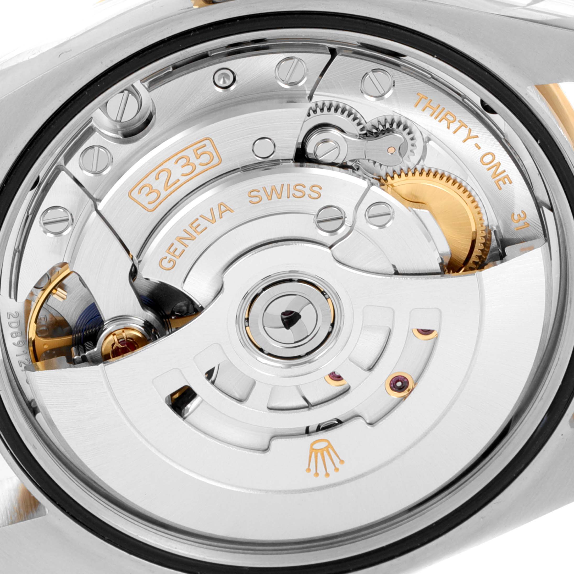 The image shows a close-up view of the Rolex Datejust 126233 Men
s Steel and Gold (two tone) Grey Dial 126233 Men
s Steel and Gold (two tone) Grey Dial watch
s movement, specifically highlighting its intricate mechanical parts and rotor.