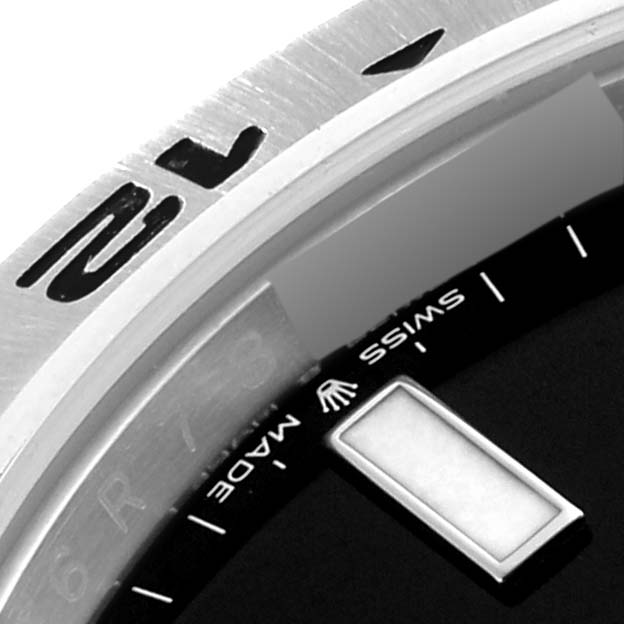 Close-up of the bezel and dial of a Rolex Explorer 226570 Men
s Stainless Steel Black Dial 226570 Men
s Stainless Steel Black Dial, showing the "Swiss Made" text and partial hour marker.