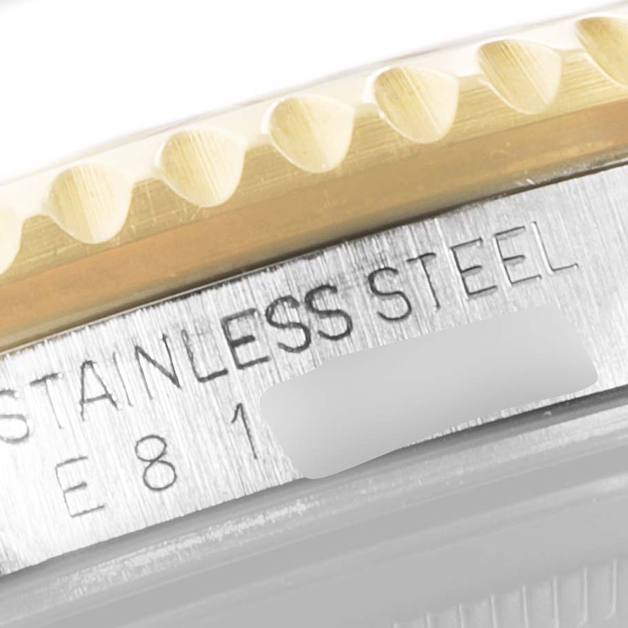 This is a close-up image showing the stainless steel bezel and part of the engraving on the Rolex GMT-Master 16713 Men's Steel and Gold (two tone) Brown Dial 16713 Men's Steel and Gold (two tone) Brown Dial watch.