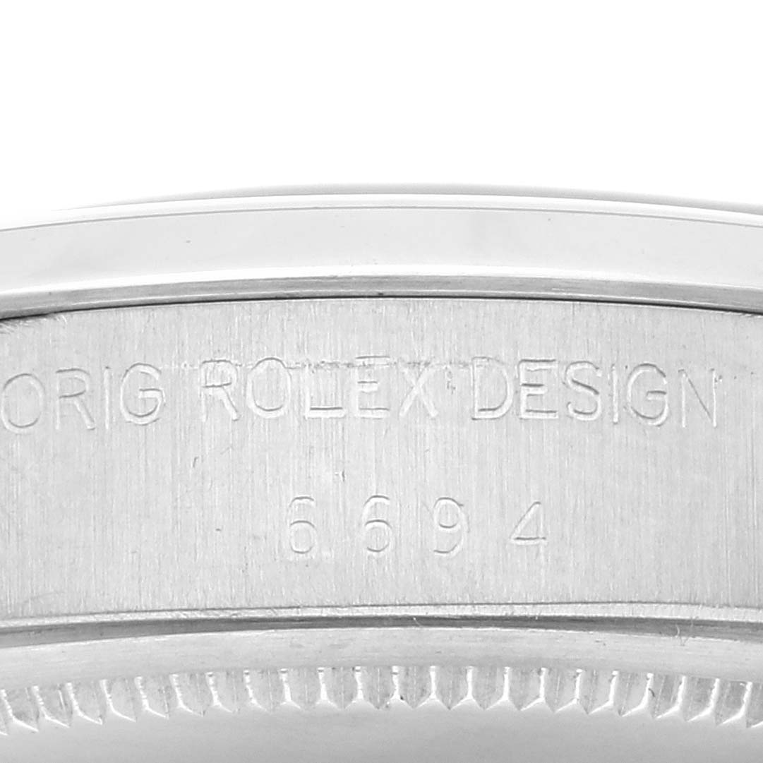 This is a close-up view of the side of a Rolex Vintage Collection 6694 Men
s Stainless Steel Silver Dial 6694 Men
s Stainless Steel Silver Dial watch, displaying the engraved words "ORIG ROLEX DESIGN 6694".