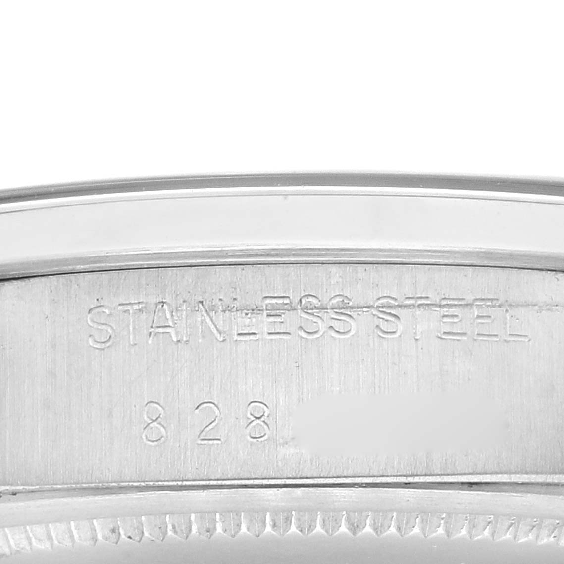 This image shows a close-up of the caseback edge of a Rolex Vintage Collection 6694 Men
s Stainless Steel Silver Dial 6694 Men
s Stainless Steel Silver Dial watch, highlighting the "Stainless Steel" engraving.