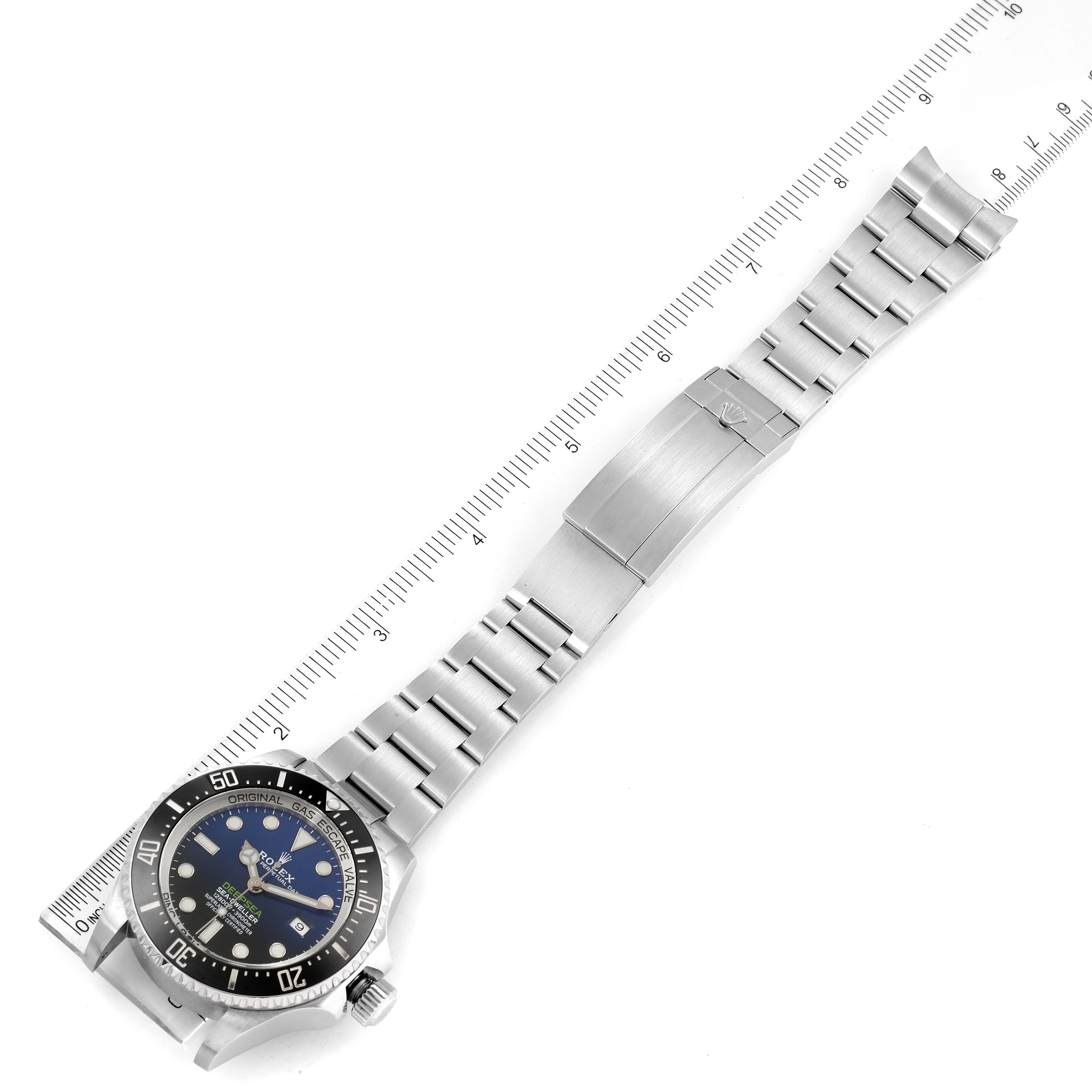 This image shows the Rolex Sea-Dweller 126660 Men
s Stainless Steel Blue Dial 126660 Men
s Stainless Steel Blue Dial watch laid flat with its bracelet fully extended, alongside a ruler for scale.