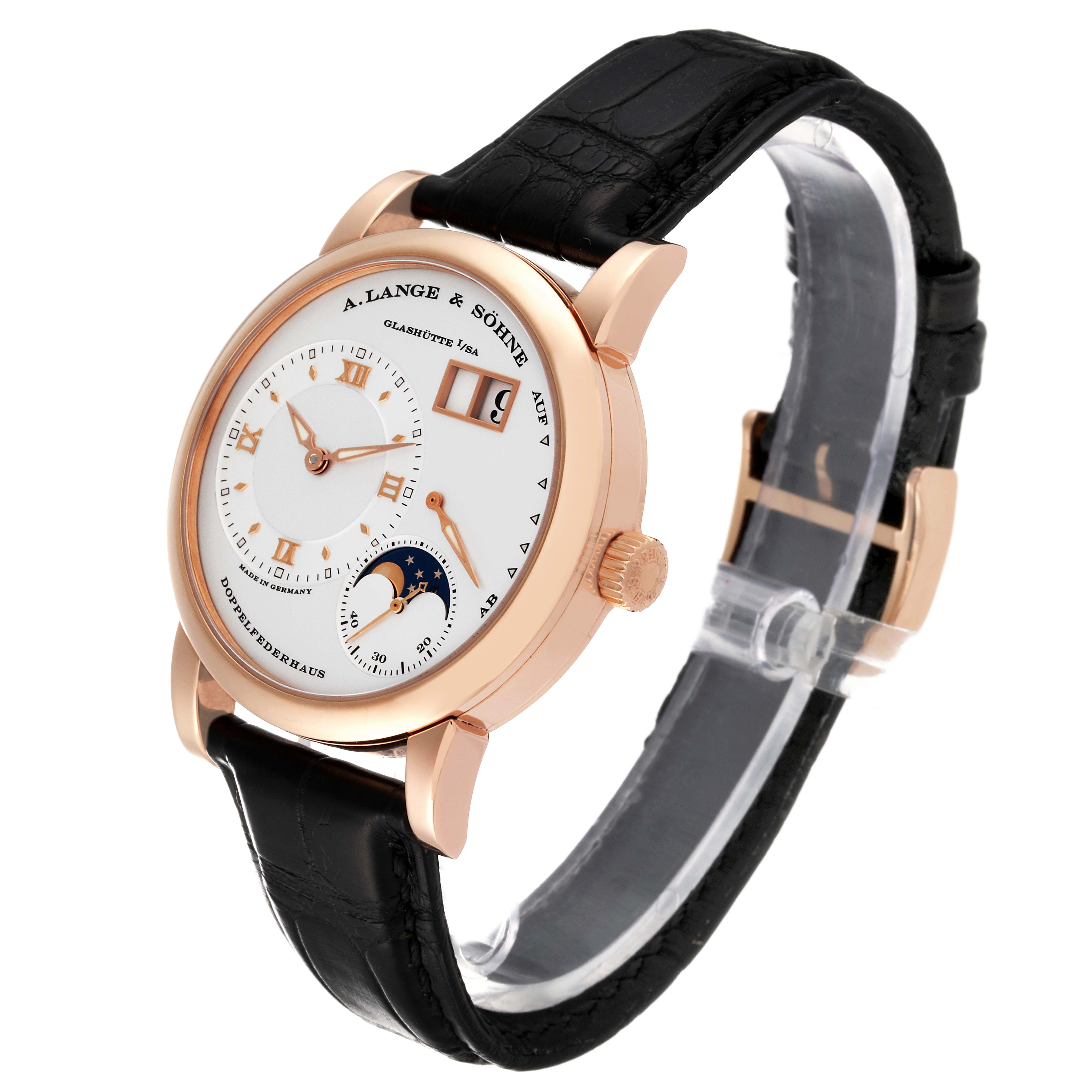 The image shows an oblique angle of a Lange 1 watch by A. Lange & Söhne, highlighting its face, crown, and black leather strap.