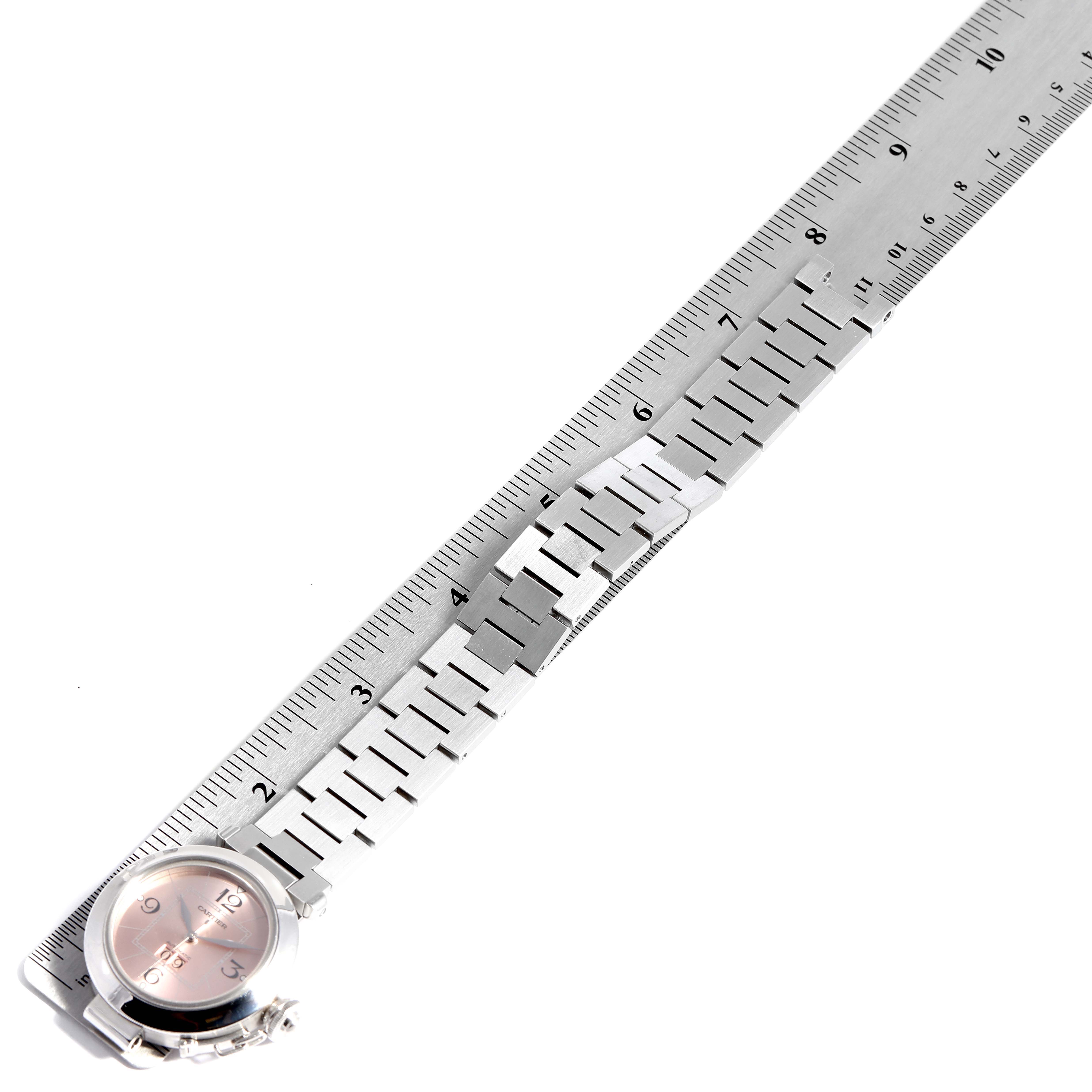 The Cartier W31058M7 Women
s Stainless Steel Pink Dial W31058M7 Women
s Stainless Steel Pink Dial Pasha Big Date 35mm Steel Ladies Watch W31058M7 is shown with a partial view of the pink dial and metal strap measured against a ruler.