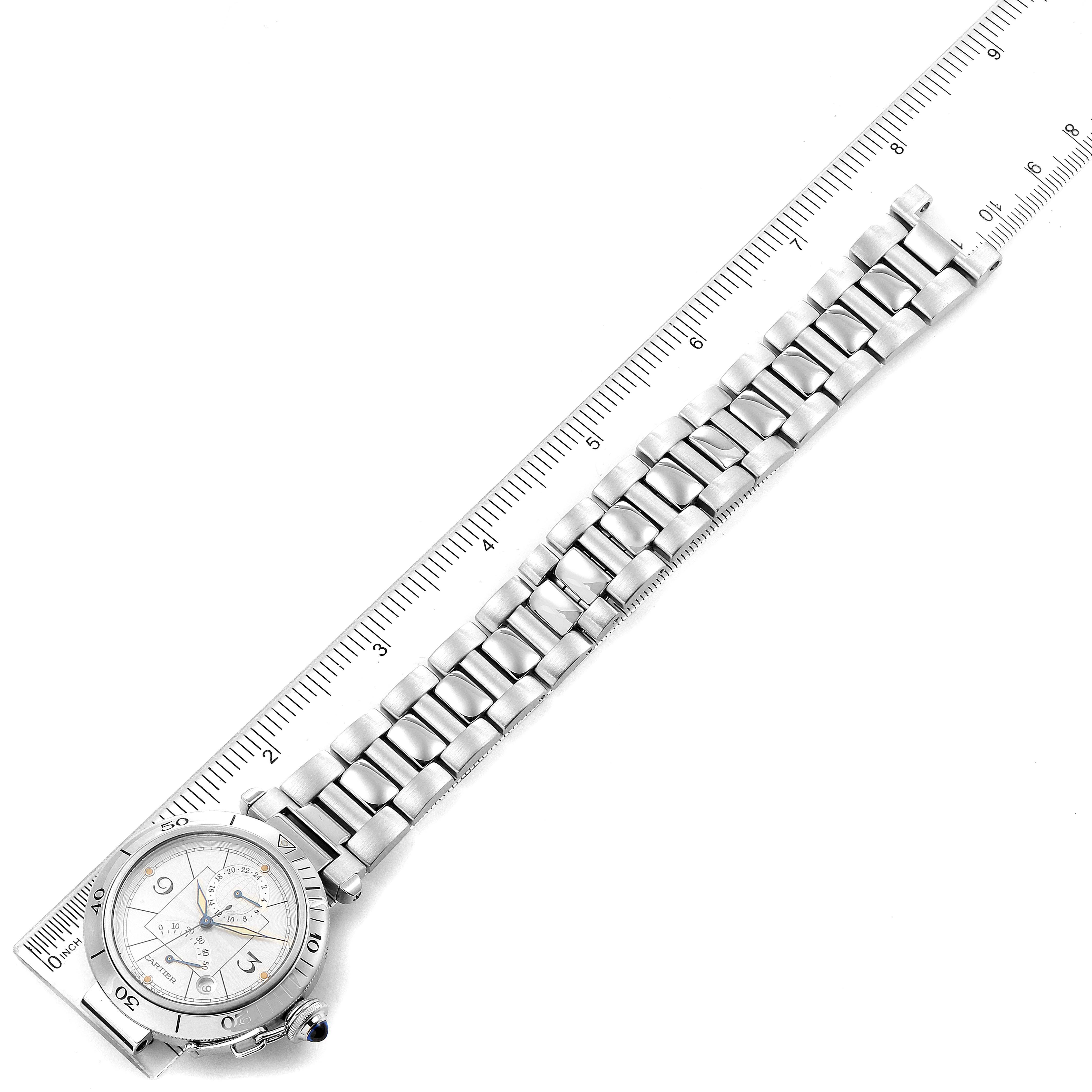 The image shows the Pasha model by Cartier from a top-down angle, highlighting its dial, case, and metal bracelet.