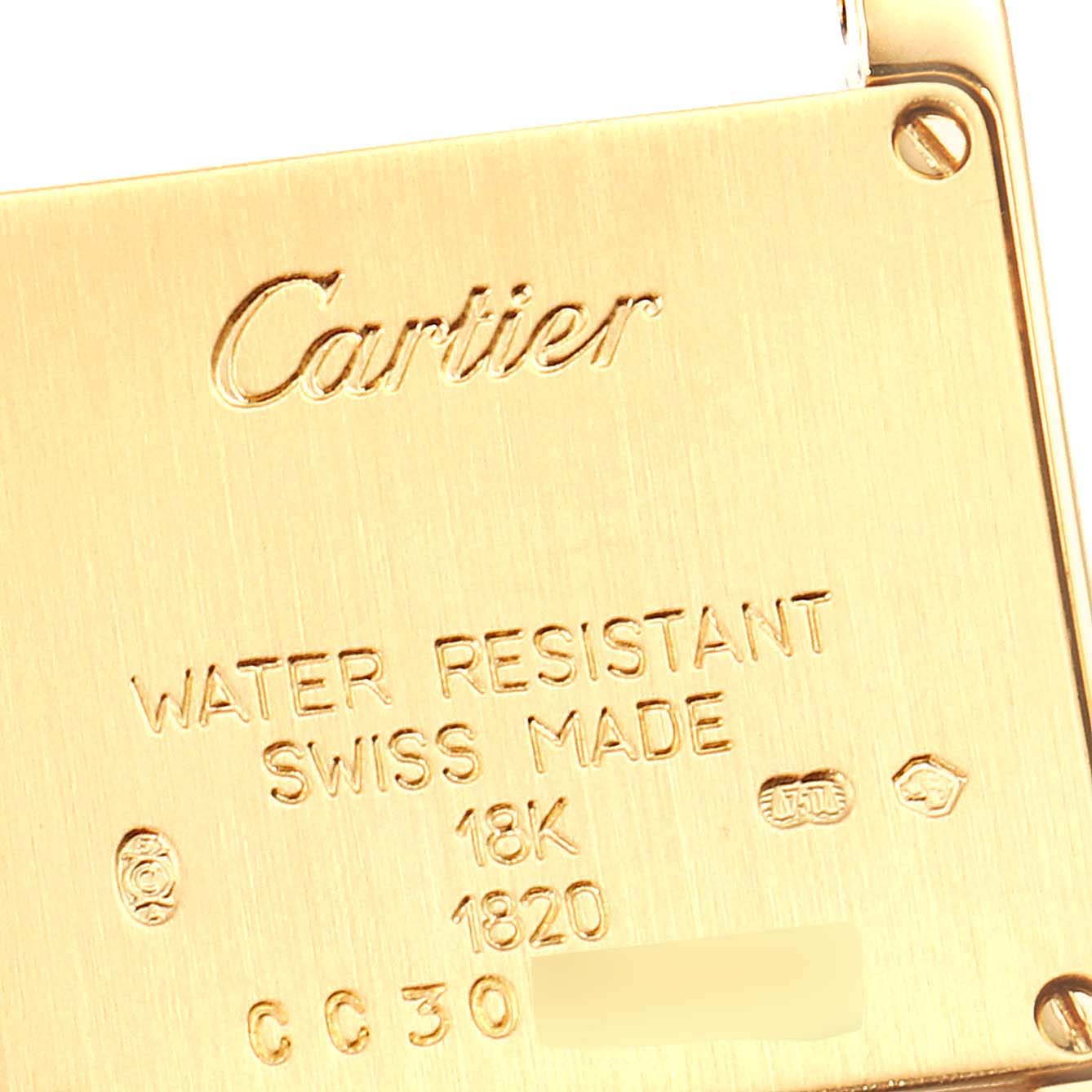 This close-up image shows the engraved back of the Cartier Tank Française watch, detailing specifications like water resistance and gold content.