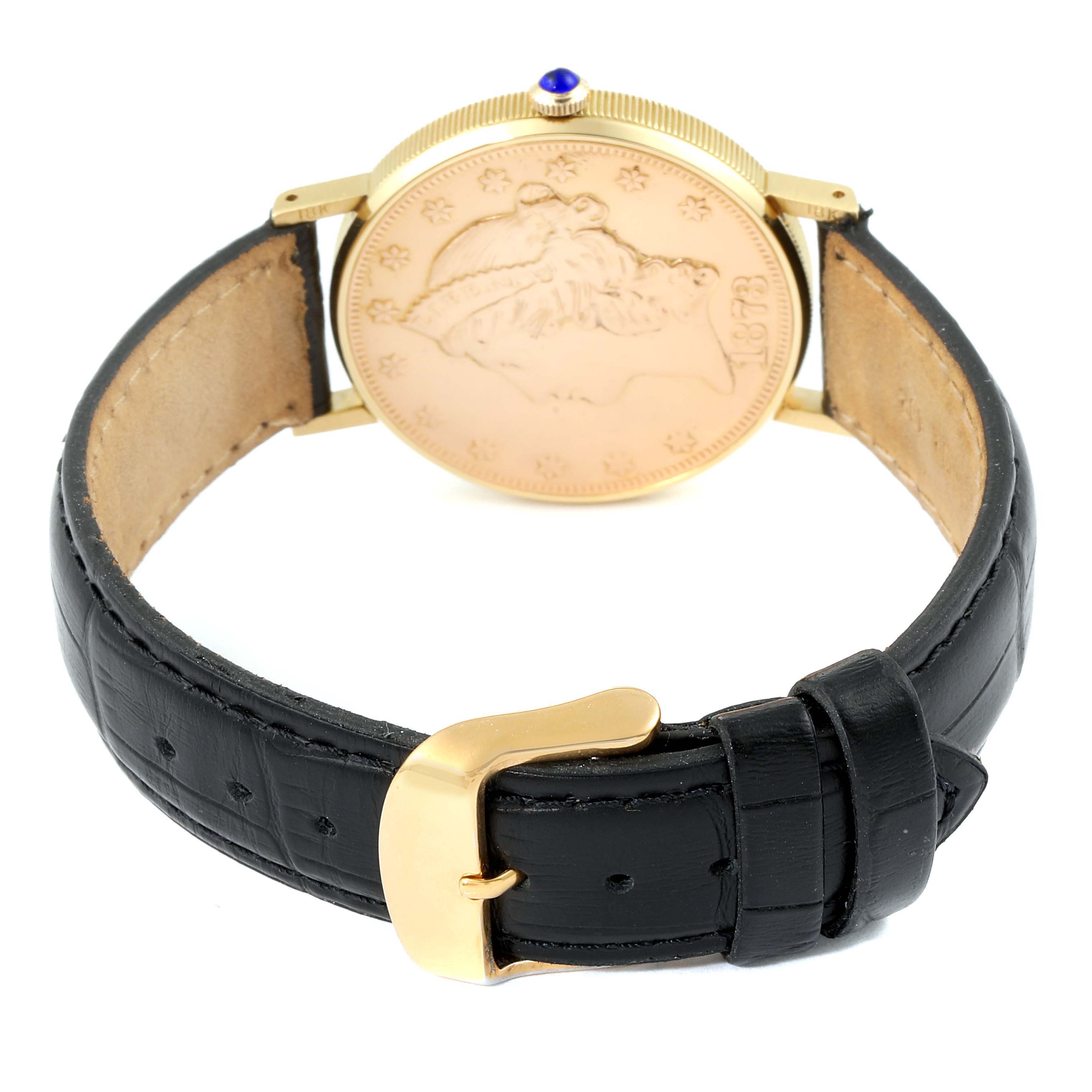 The image shows the back of the Baume & Mercier  Men's Yellow Gold Black Dial  Men's Yellow Gold Black Dial 1873 model, featuring the gold coin case and black leather strap with gold buckle.