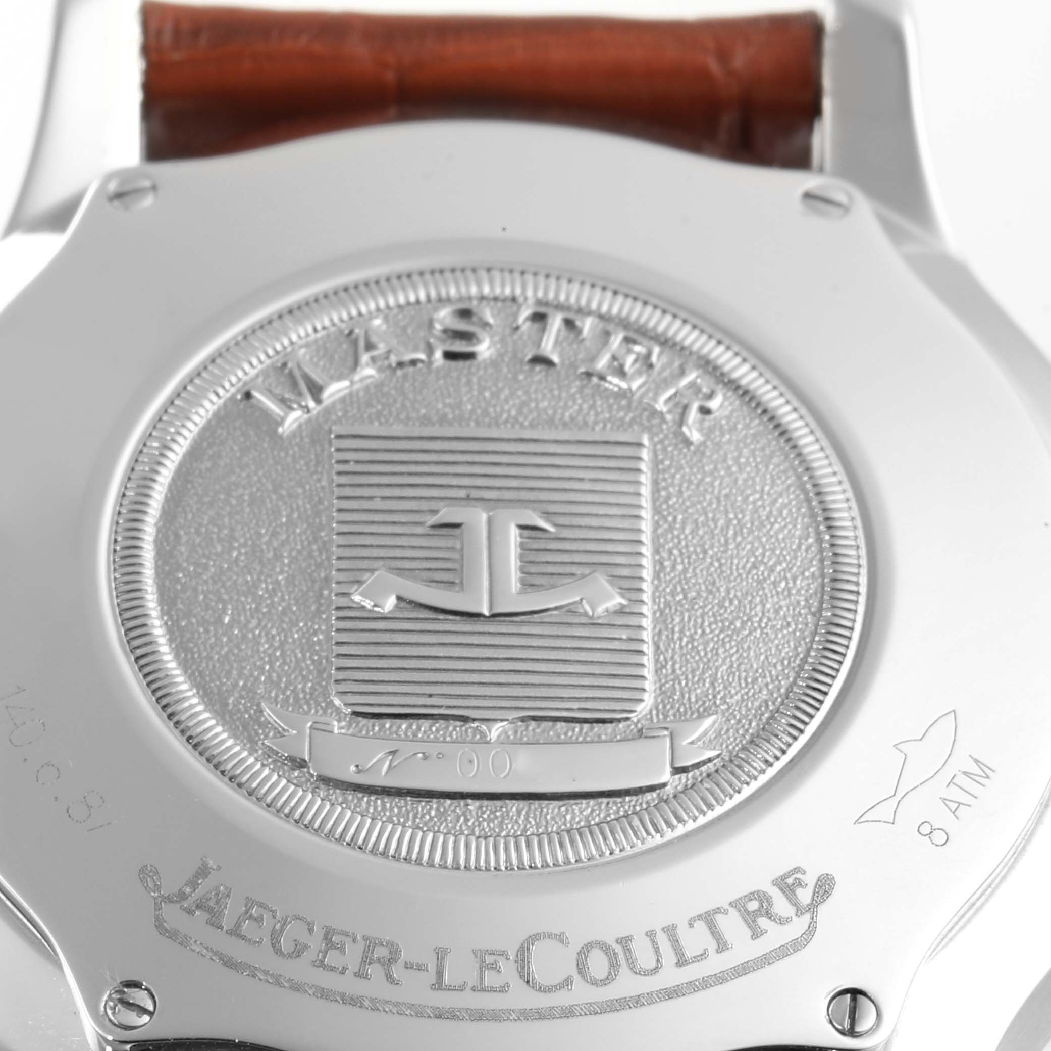 The image shows the back case of the Jaeger-LeCoultre Master model watch, highlighting the logo, engravings, and a brown strap.