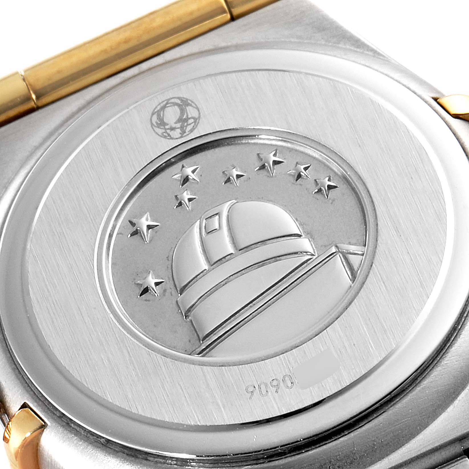 This image shows the case back of the Omega 1267.75.00 Women
s Steel and Gold (two tone) Mother of Pearl Dial 1267.75.00 Women
s Steel and Gold (two tone) Mother of Pearl Dial Constellation 95 Mother of Pearl Diamond Ladies Watch 1267.75.00, featuring an embossed observatory design.