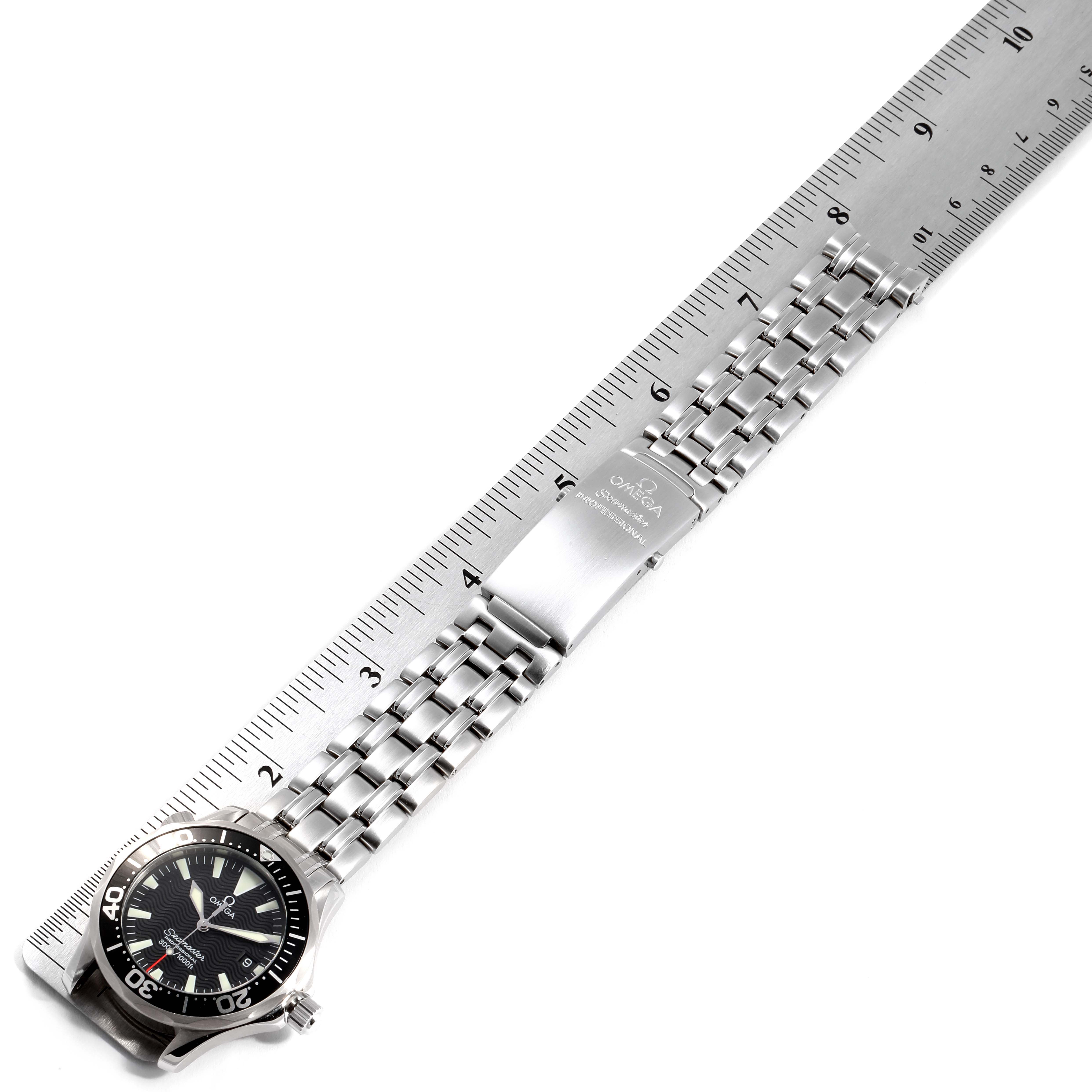 The image shows a top-down view of the Omega Seamaster 2262.50.00  Men
s Stainless Steel Black Dial 2262.50.00  Men
s Stainless Steel Black Dial watch and its metal bracelet against a ruler.