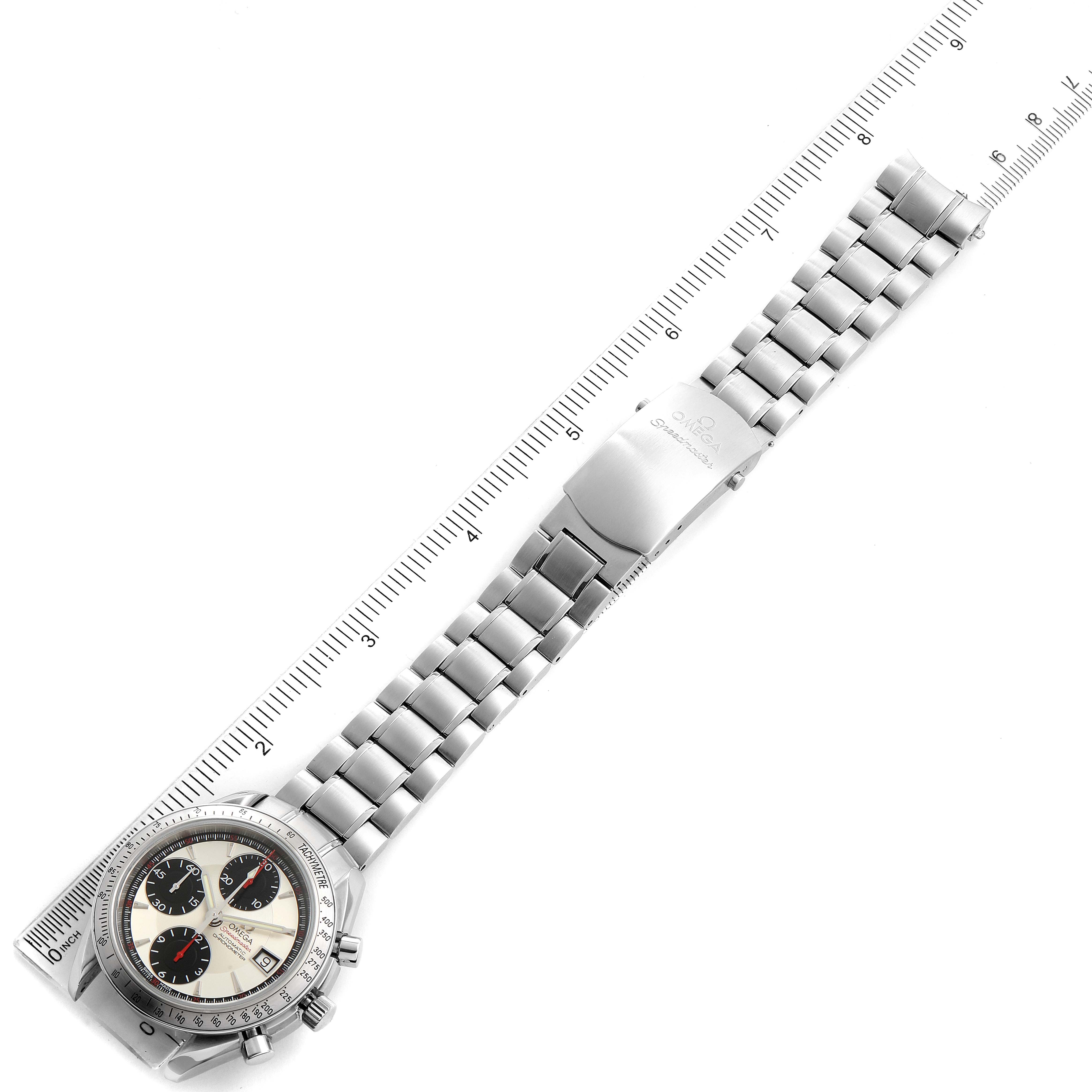 The image shows the Omega Speedmaster 3211.31.00 Men
s Stainless Steel Silver Dial 3211.31.00 Men
s Stainless Steel Silver Dial watch from a top-down angle, highlighting the face, bezel, and metal bracelet alongside a ruler.