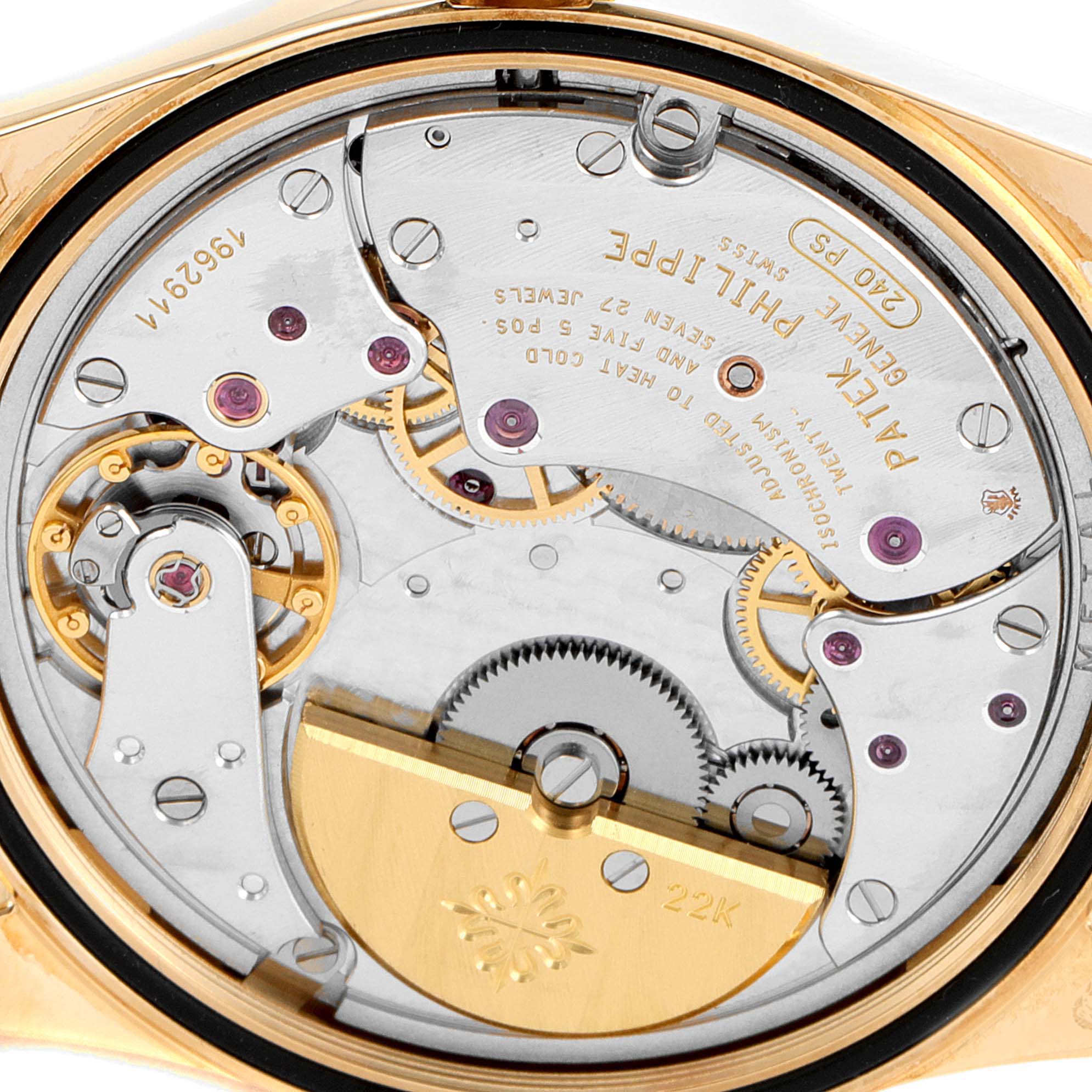 This is a close-up of the movement inside a Patek Philippe Calatrava 5000J Men's Yellow Gold Black Dial 5000J Men's Yellow Gold Black Dial watch, showing gears, jewels, and gold components.