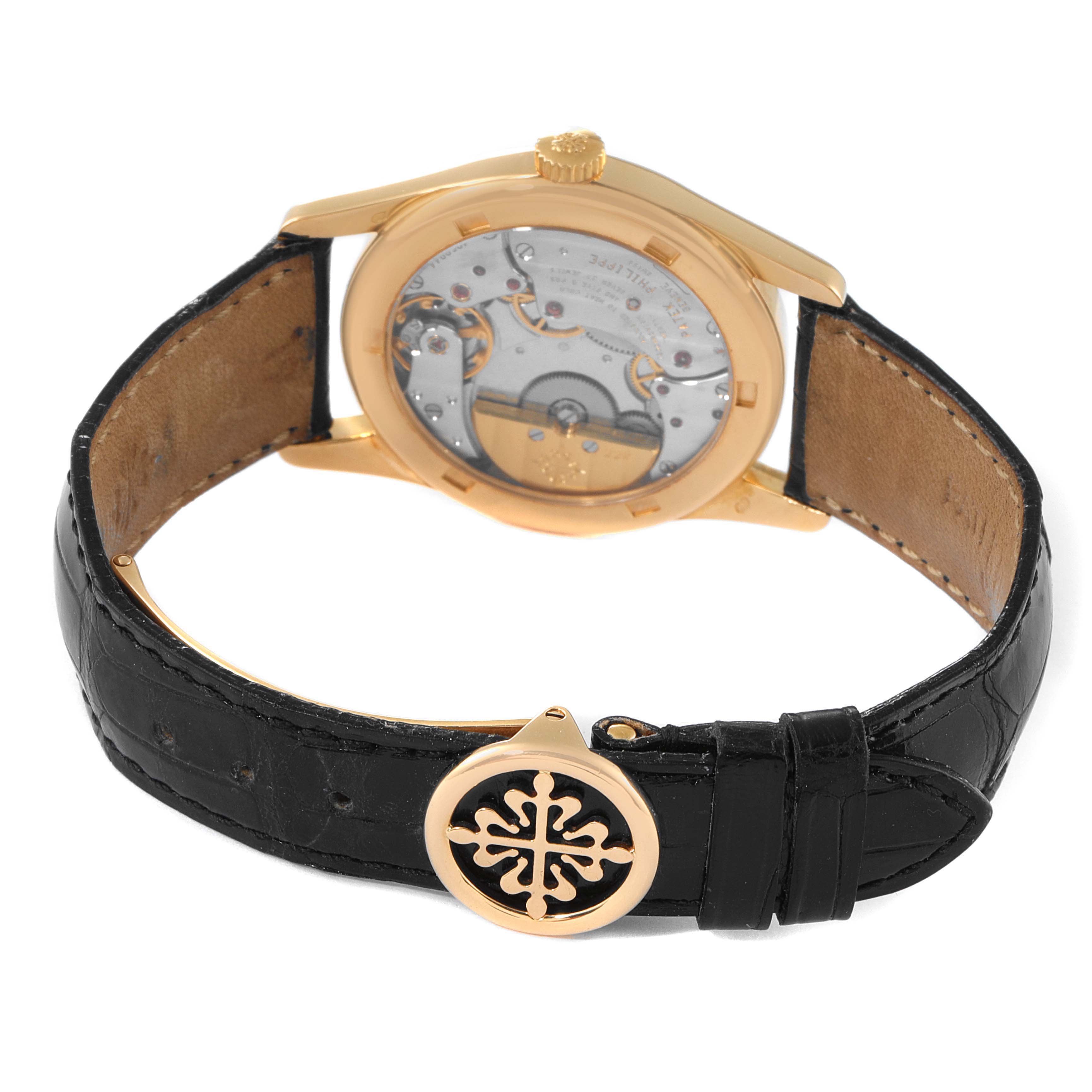 The image shows the rear view of a Patek Philippe Calatrava 5000J Men's Yellow Gold Black Dial 5000J Men's Yellow Gold Black Dial watch, showcasing its movement and black leather strap with a branded clasp.