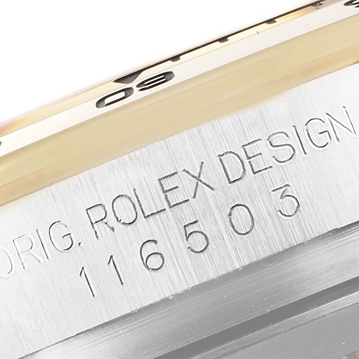 Close-up of a Rolex Daytona 116503 Men's Steel and Gold (two tone) Black Dial 116503 Men's Steel and Gold (two tone) Black Dial watch showing part of the bezel and case with engraved model number 116503.