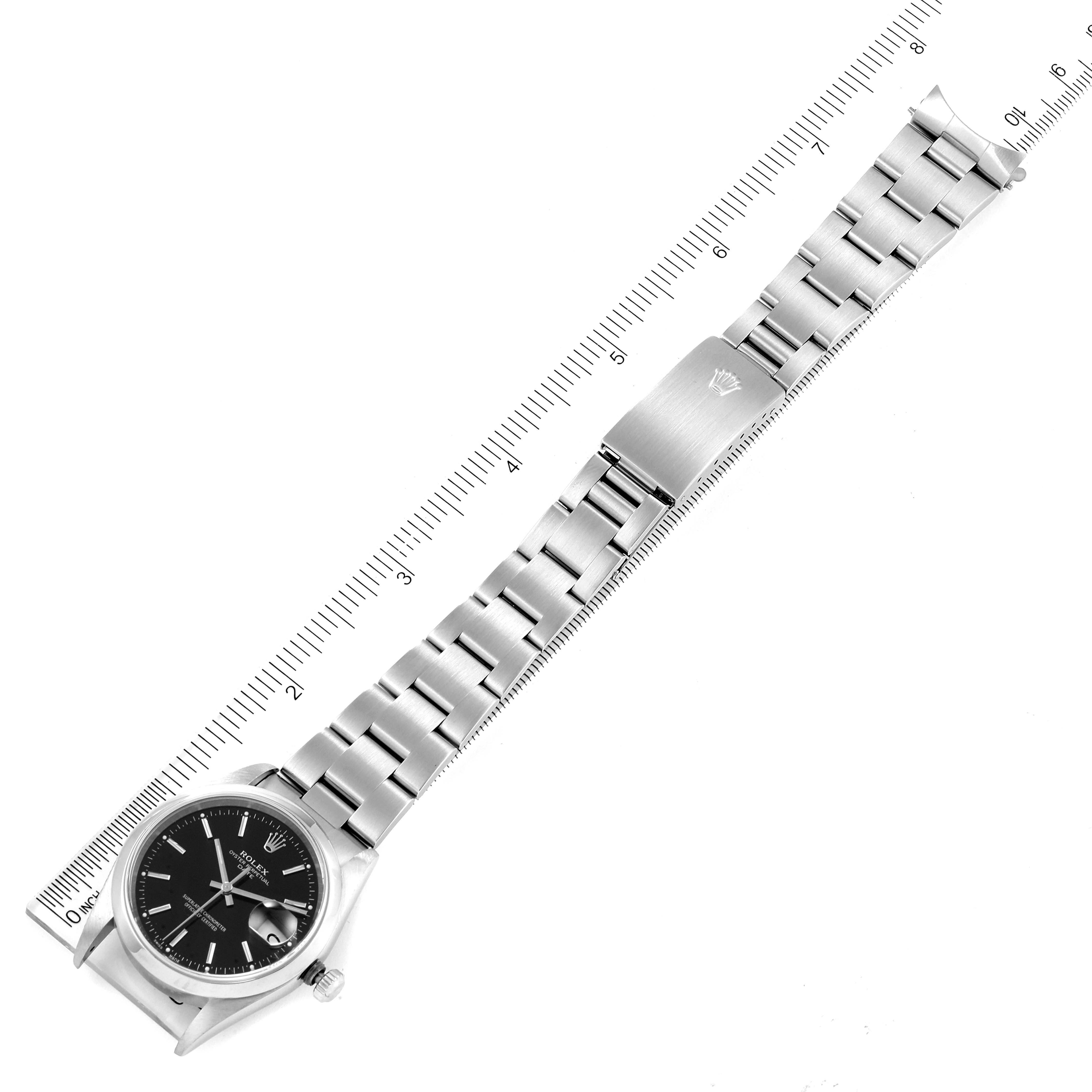 The Rolex Date 15200 Men's Stainless Steel Black Dial 15200 Men's Stainless Steel Black Dial model watch shown is laid flat, displaying the face, bracelet, and clasp with a ruler for scale.
