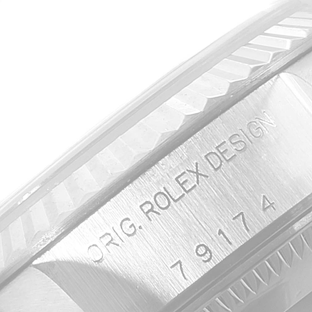 The image shows a close-up of the bezel and case side of a Rolex Datejust 79174 Women's Stainless Steel Black Dial 79174 Women's Stainless Steel Black Dial watch with engraved text.