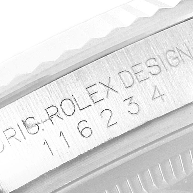 The image shows a close-up of the case side of a Rolex Datejust 116234 Men
s Stainless Steel Black Dial 116234 Men
s Stainless Steel Black Dial model, highlighting the engraved model number and "Rolex Design" text.