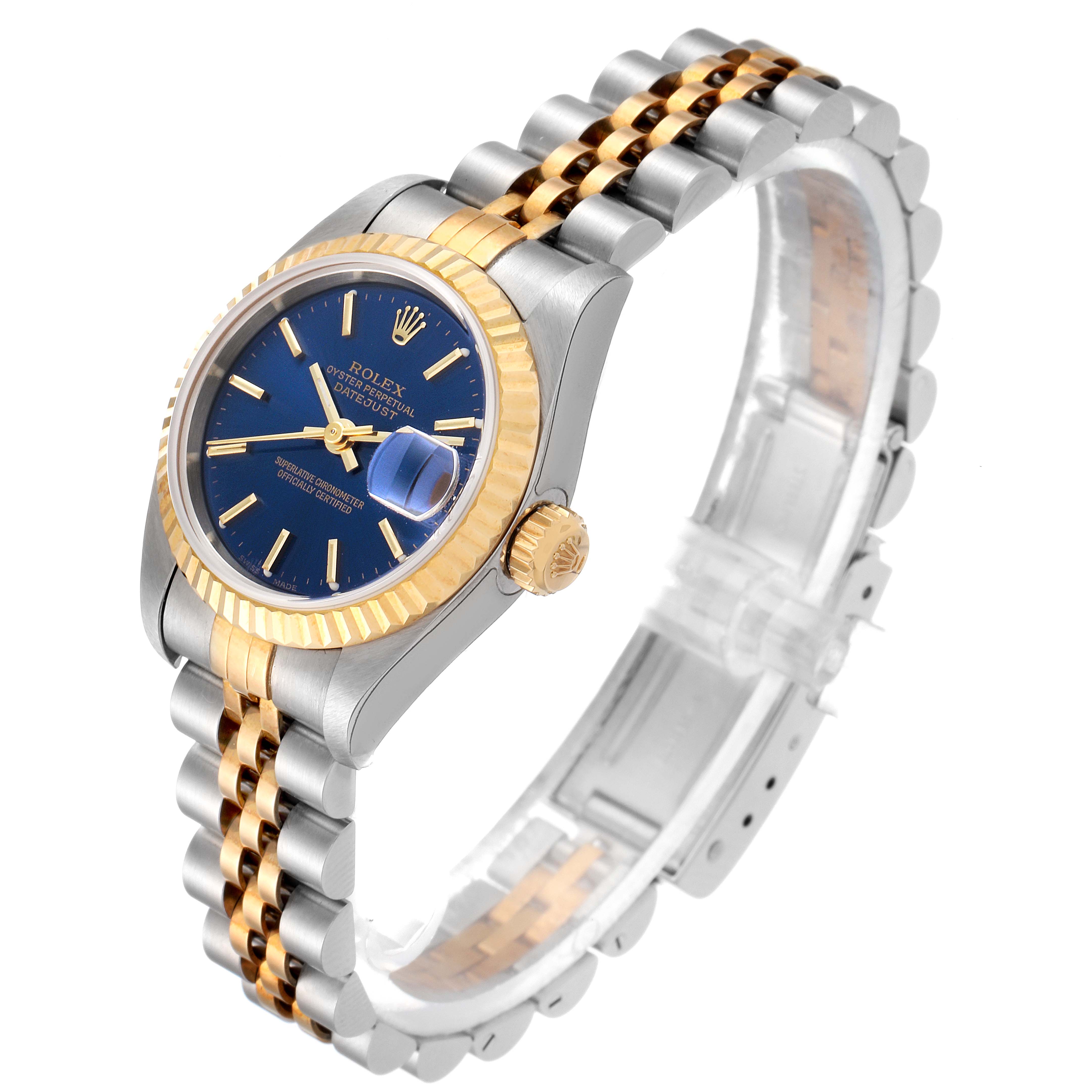 This image shows a Rolex Datejust 79173 Women's Steel and Gold (two tone) Blue Dial 79173 Women's Steel and Gold (two tone) Blue Dial watch from an angled side view, highlighting the blue dial, fluted bezel, gold crown, and two-tone bracelet.