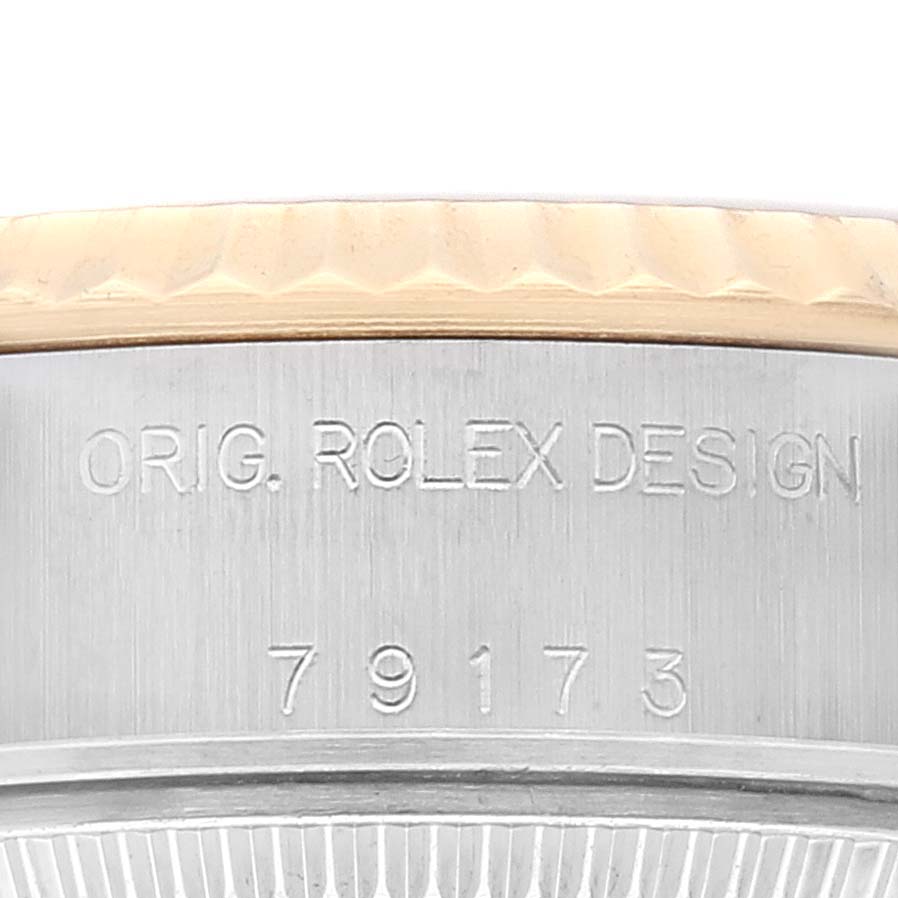 This image shows a close-up of the side of a Rolex Datejust 79173 Women's Steel and Gold (two tone) Champagne Dial 79173 Women's Steel and Gold (two tone) Champagne Dial watch case with the design inscription and model number visible.