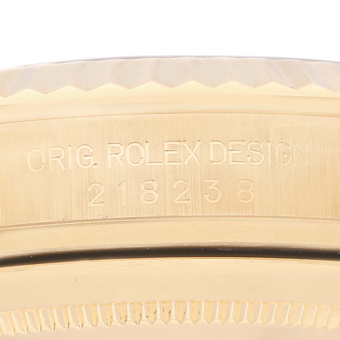This close-up image shows the engraved serial number and design details on the case of a Rolex President 218238 Men's Yellow Gold Champagne Dial 218238 Men's Yellow Gold Champagne Dial model watch.