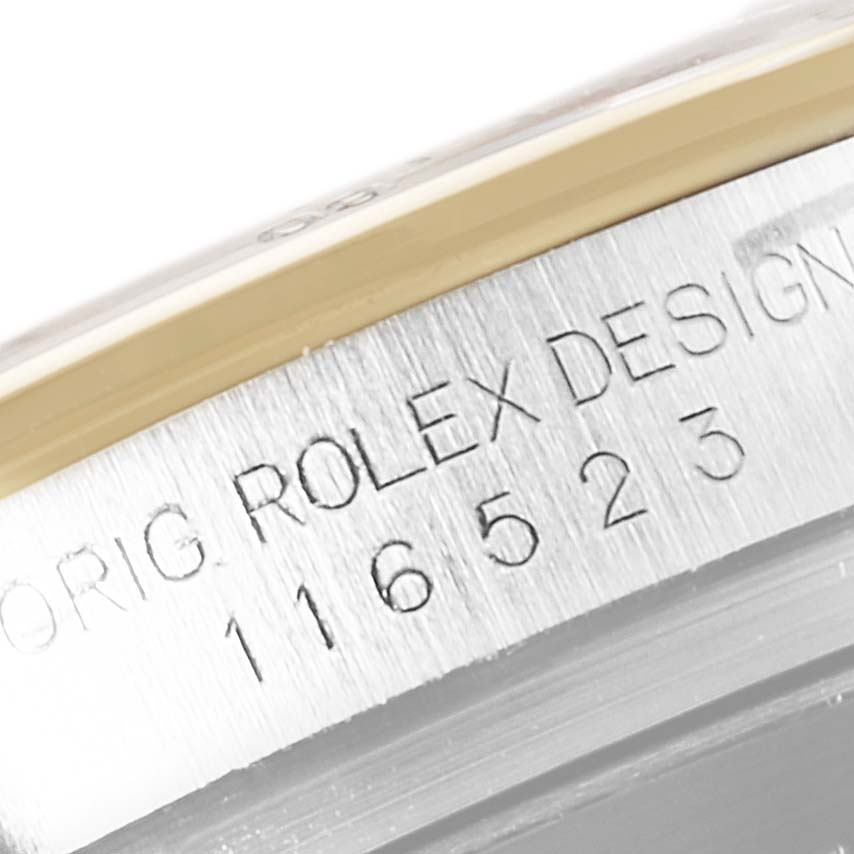 The image shows a close-up of the engravings on the side of a Rolex Daytona 116523 Men
s Steel and Gold (two tone) Black Dial 116523 Men
s Steel and Gold (two tone) Black Dial watch case.